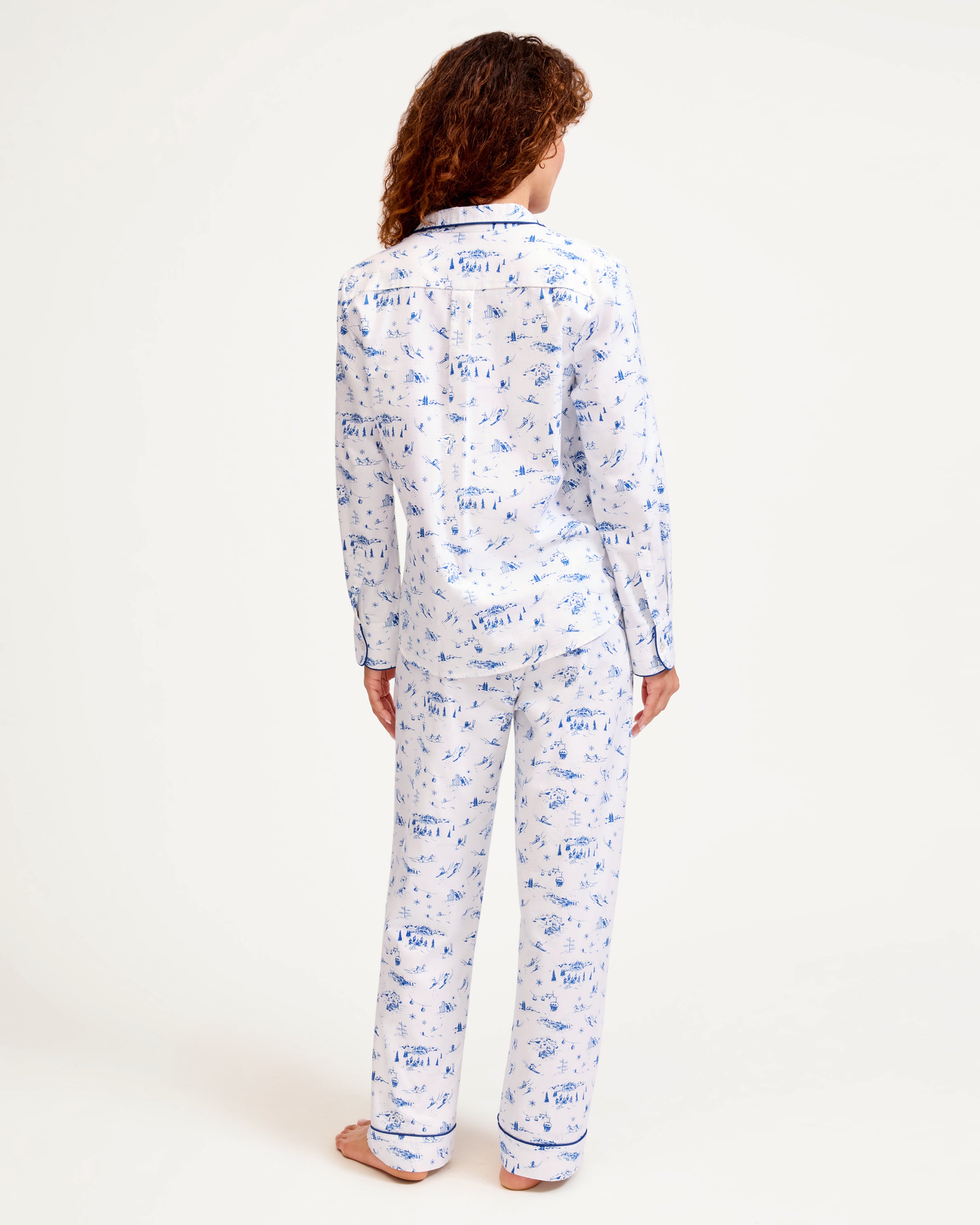 Women's Twill Pajama Set in Chalet Toile, featuring a white long-sleeve button-up shirt and matching pants with blue piping and a blue toile pattern, neatly displayed on a white background.