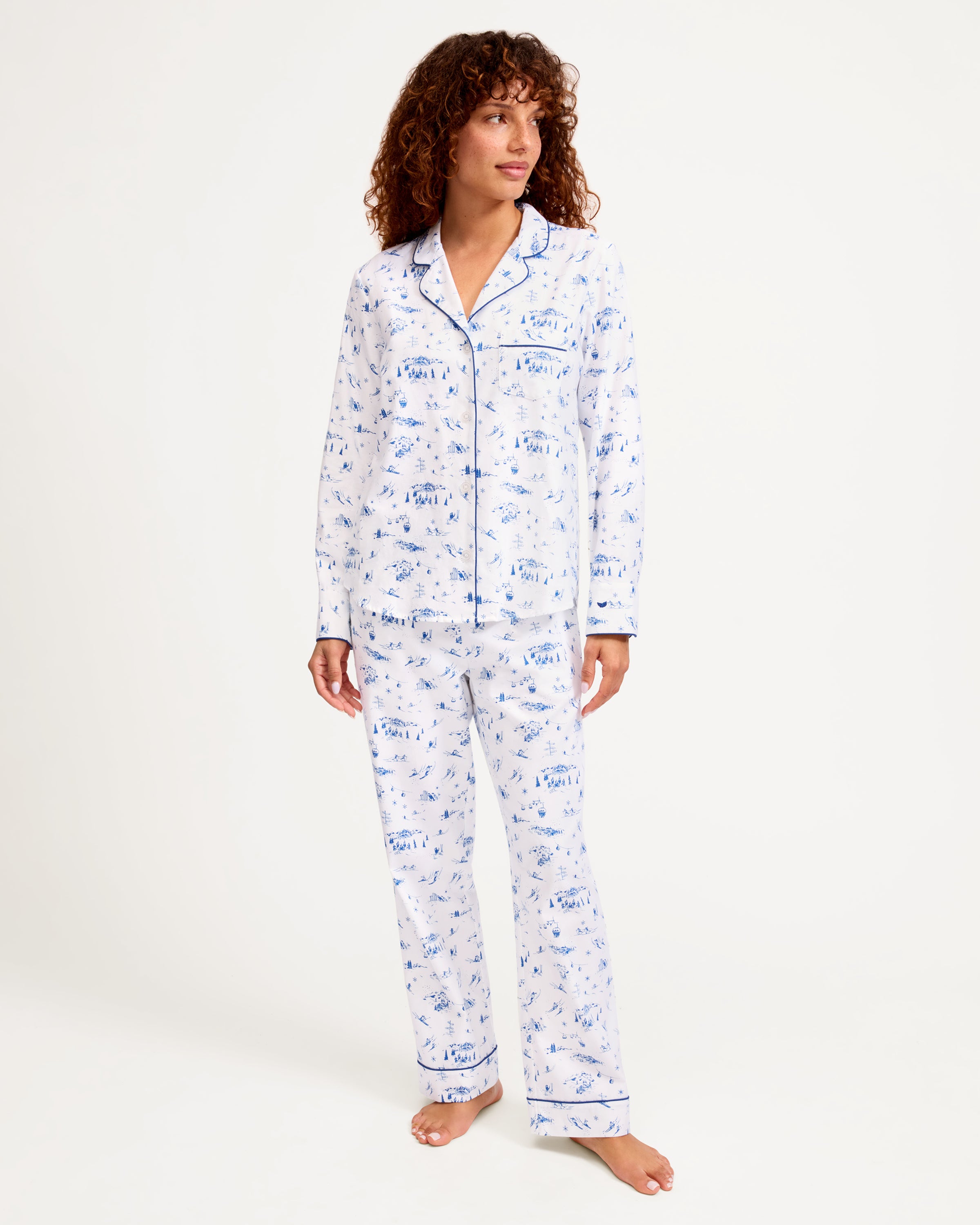 Women's Twill Pajama Set in Chalet Toile, featuring a white long-sleeve button-up shirt and matching pants with blue piping and a blue toile pattern, neatly displayed on a white background.