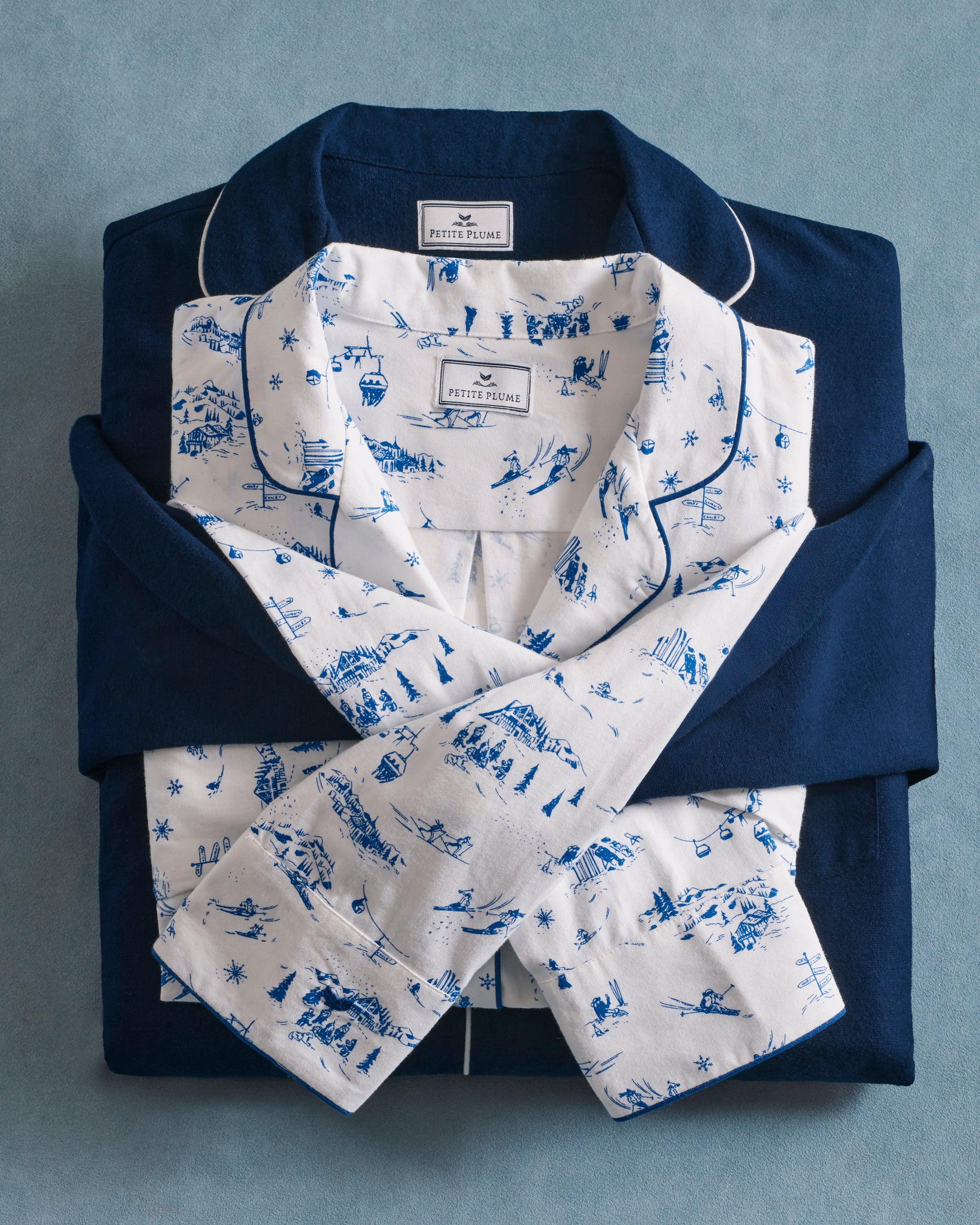 Women's Twill Pajama Set in Chalet Toile, featuring a white long-sleeve button-up shirt and matching pants with blue piping and a blue toile pattern, neatly displayed on a white background.