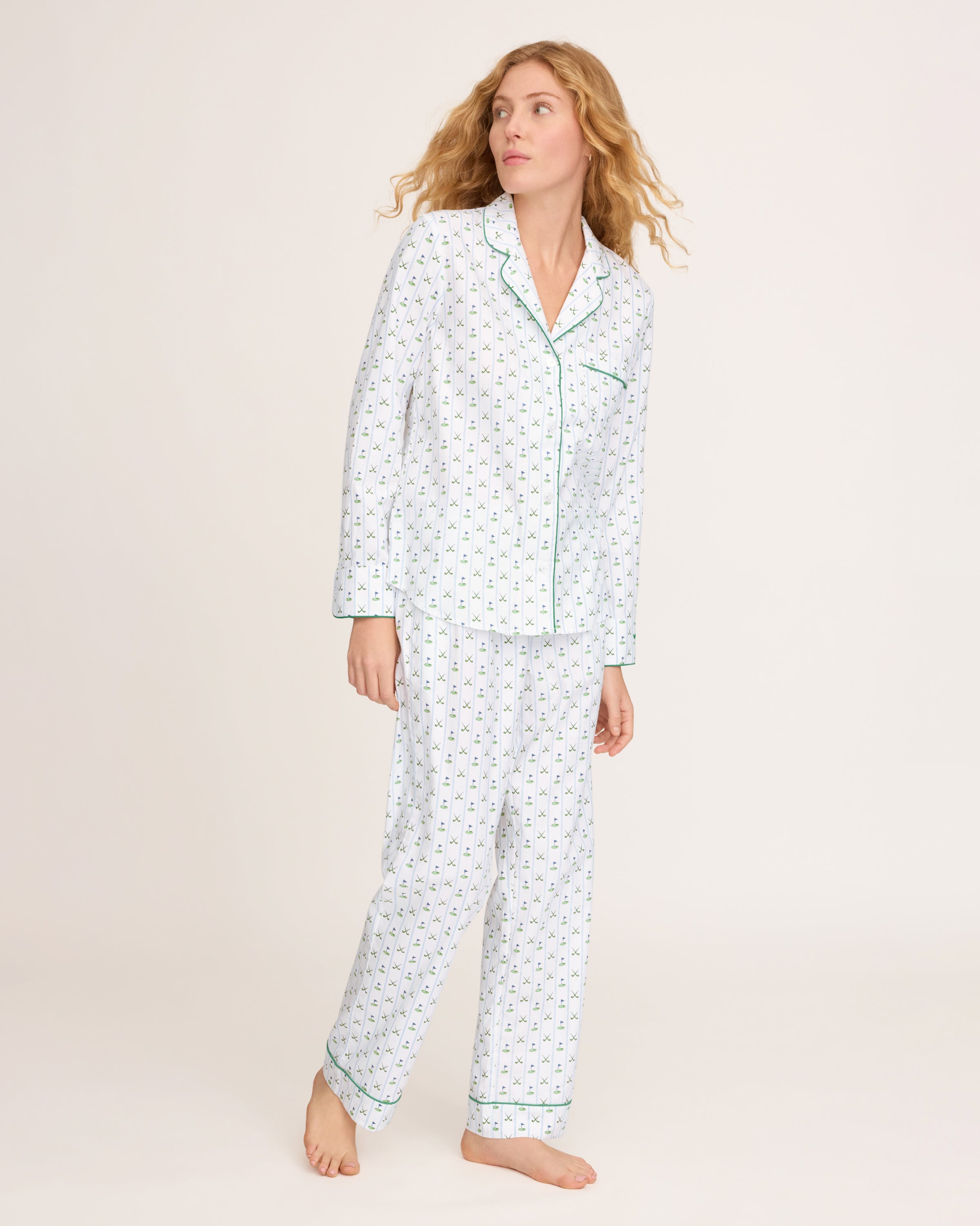 The Women's Twill Pajama Set in Fairway Stripe features a neatly folded white set with green stripes, including a long-sleeve button-up top with a chest pocket and matching drawstring pants.