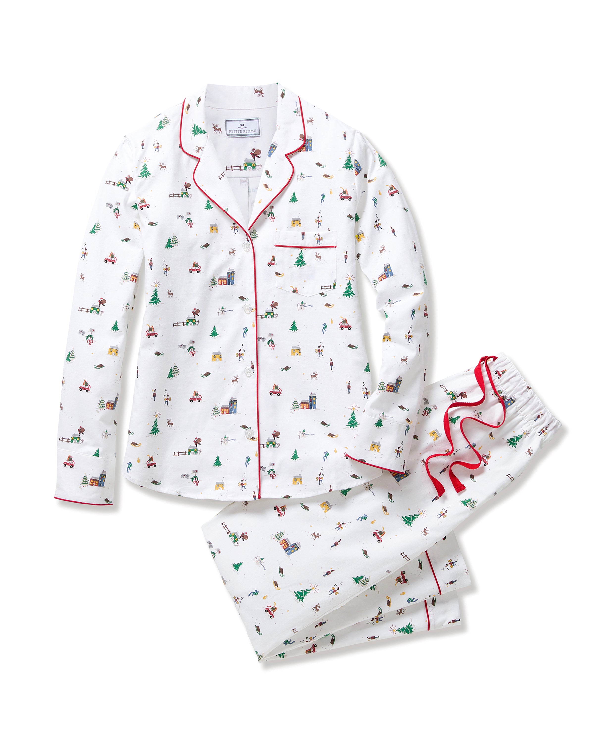 Women's Twill Pajama Set in Holiday Town: white pajama set with red piping, featuring festive prints of Christmas trees, cars, and skiers. Includes a long-sleeve button-up top with a pocket and matching drawstring pants.
