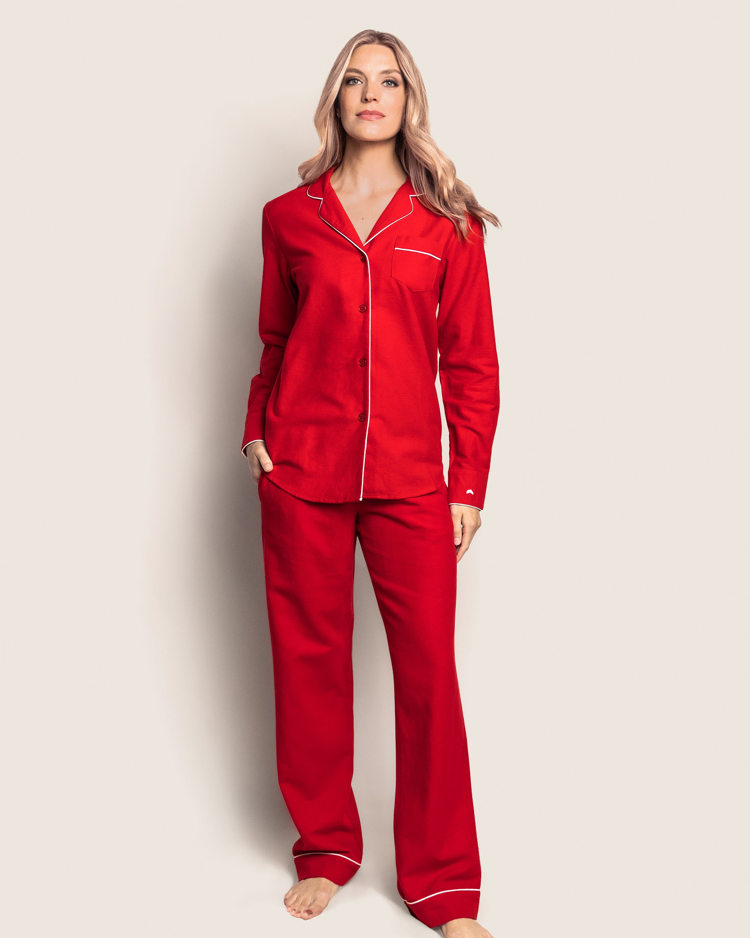 A person stands against a plain background wearing Petite Plumes Womens Flannel Pajama Set in red.