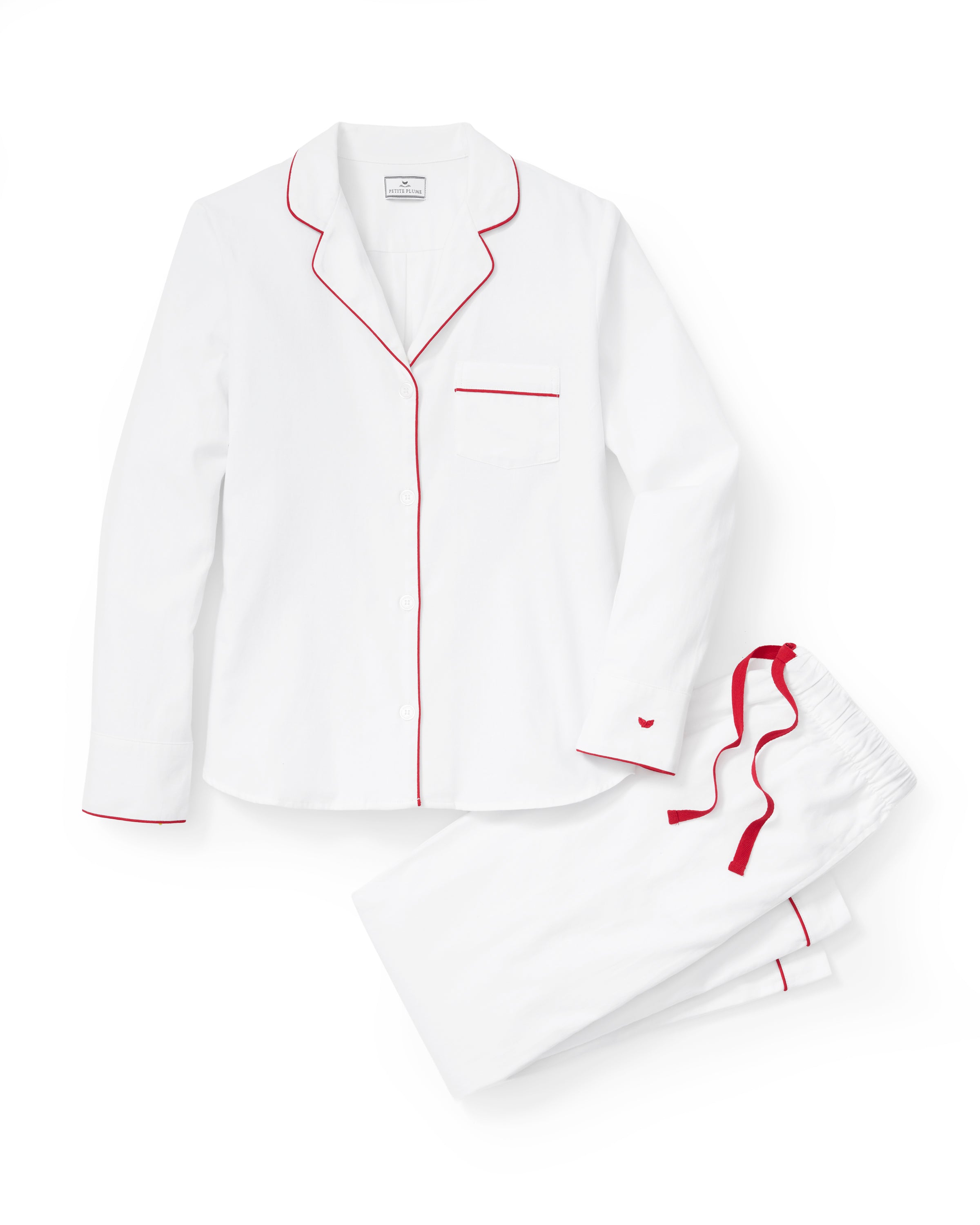 A woman stands barefoot in the Women's Twill Pajama Set in White with Red Piping against a plain, light background.