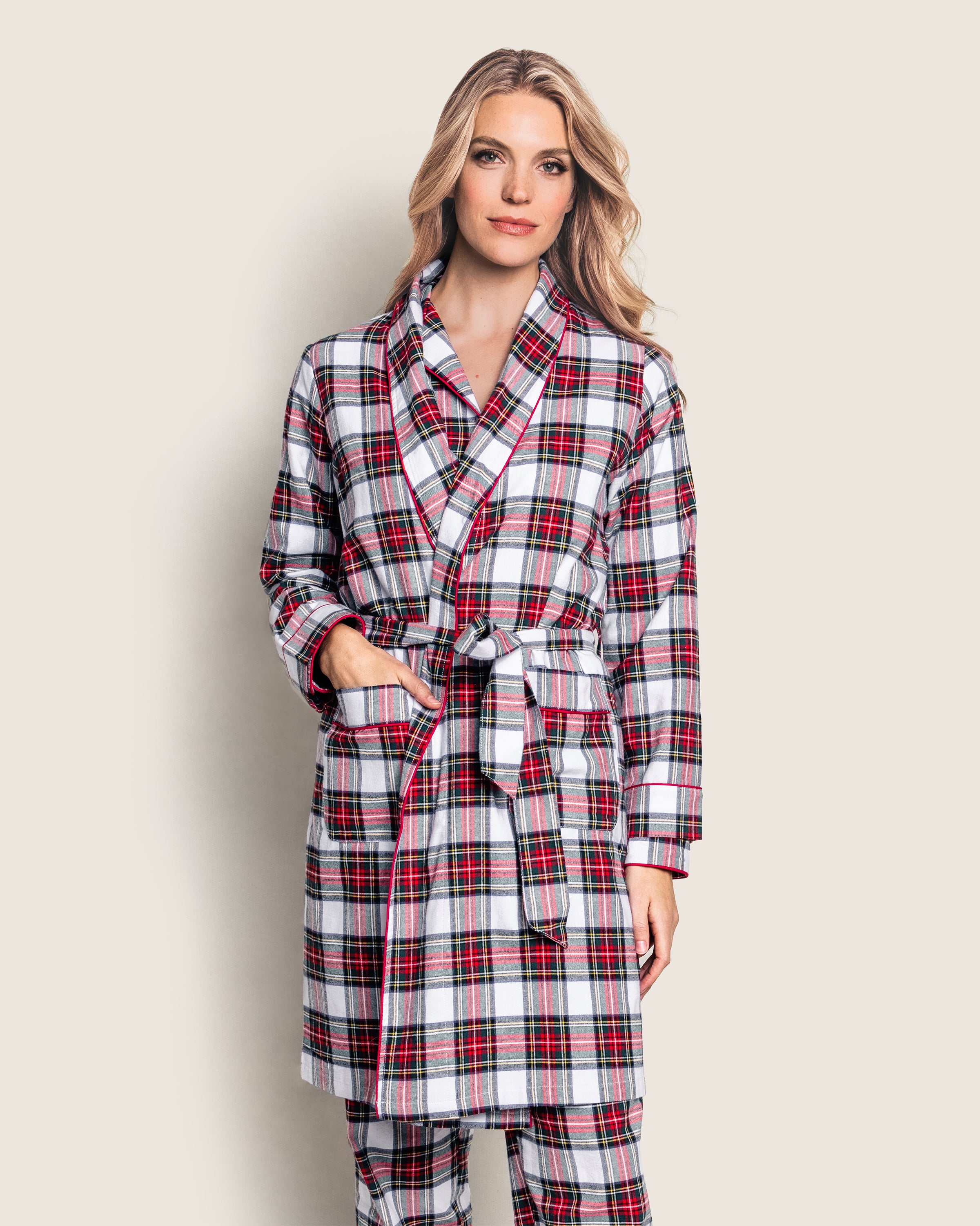 Against a plain background, a person is wearing Petite Plumes Womens Brushed Cotton Robe in Balmoral Tartan. The red, black, and white checks complement their long, wavy blonde hair and are cinched at the waist with the matching belt.