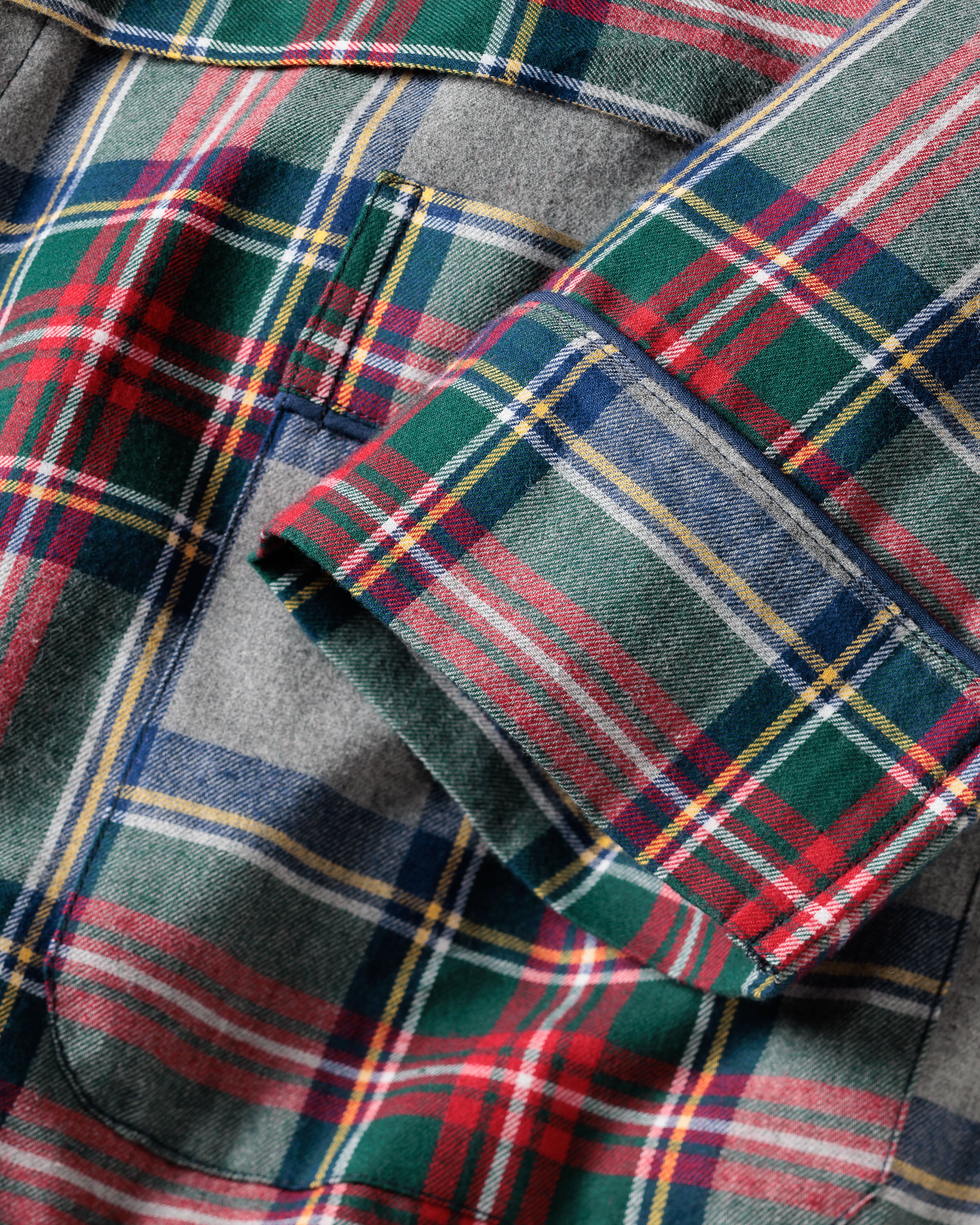Close-up of the Womens Brushed Cotton Robe in Westminster Tartan by Petite Plume, showcasing a pocket with red, green, blue, and yellow stripes. The pocket has a flap, and the brushed cotton texture suggests soft luxury sleepwear inspired by Scottish tradition.