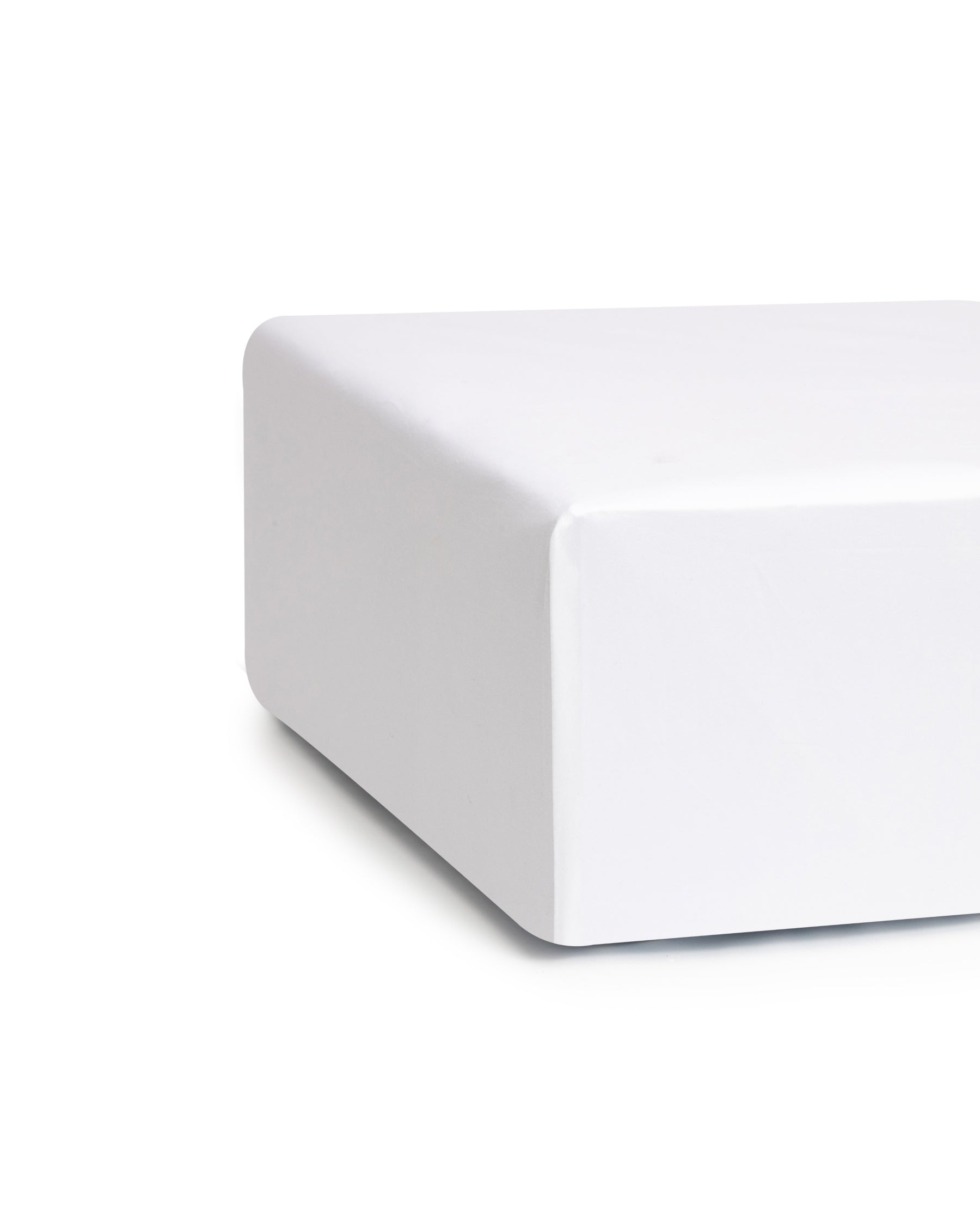 Close-up of a corner of the Signature Luxe Sateen Crib Sheet in White by Petite Plume, made from premium cotton with smooth lines and a seamless finish. The sharp edge reflects luxury, standing out against the unfocused background.