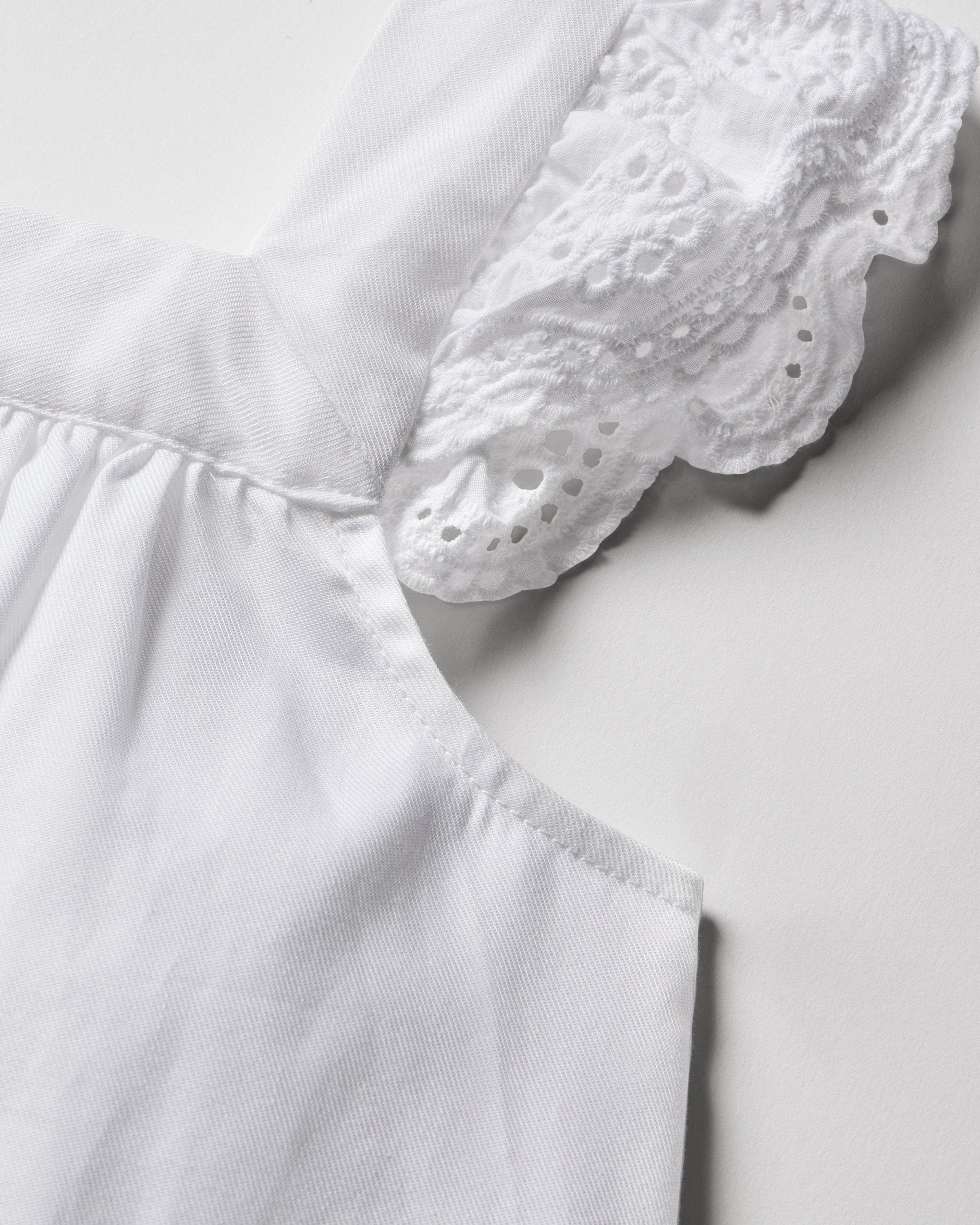 A close-up of the Girls Twill Clara Nightgown in White by Petite Plume showcases a lace-trimmed sleeve. The soft, quality cotton fabric is slightly gathered at the seam, featuring intricate lacework against a plain background.