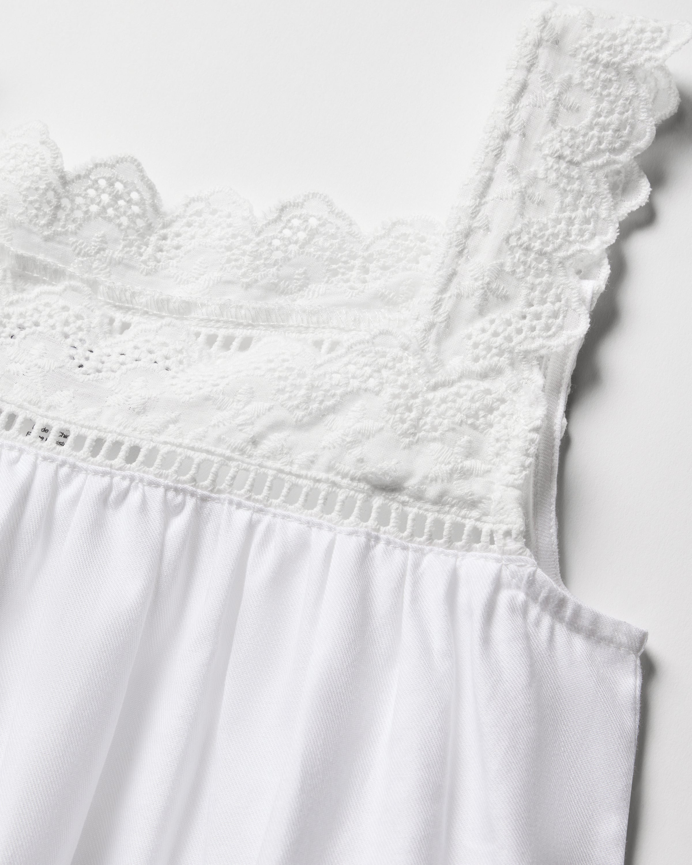 Close-up of the Girls Twill Esme Nightgown in White by Petite Plume, showcasing intricate lace detailing on the straps and neckline, crafted from yarn-dyed cotton with a smooth drape.