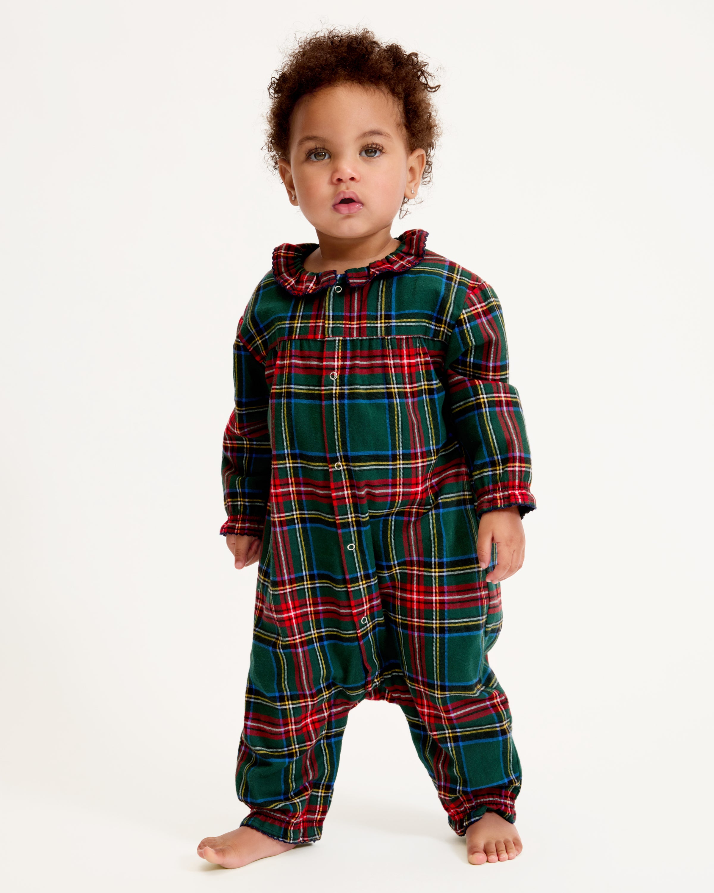 The Baby's Brushed Twill Madeline Romper in Kensington Tartan features a green, red, and yellow plaid print, ruffled collar, button front, and gathered cuffs at the wrists and ankles.