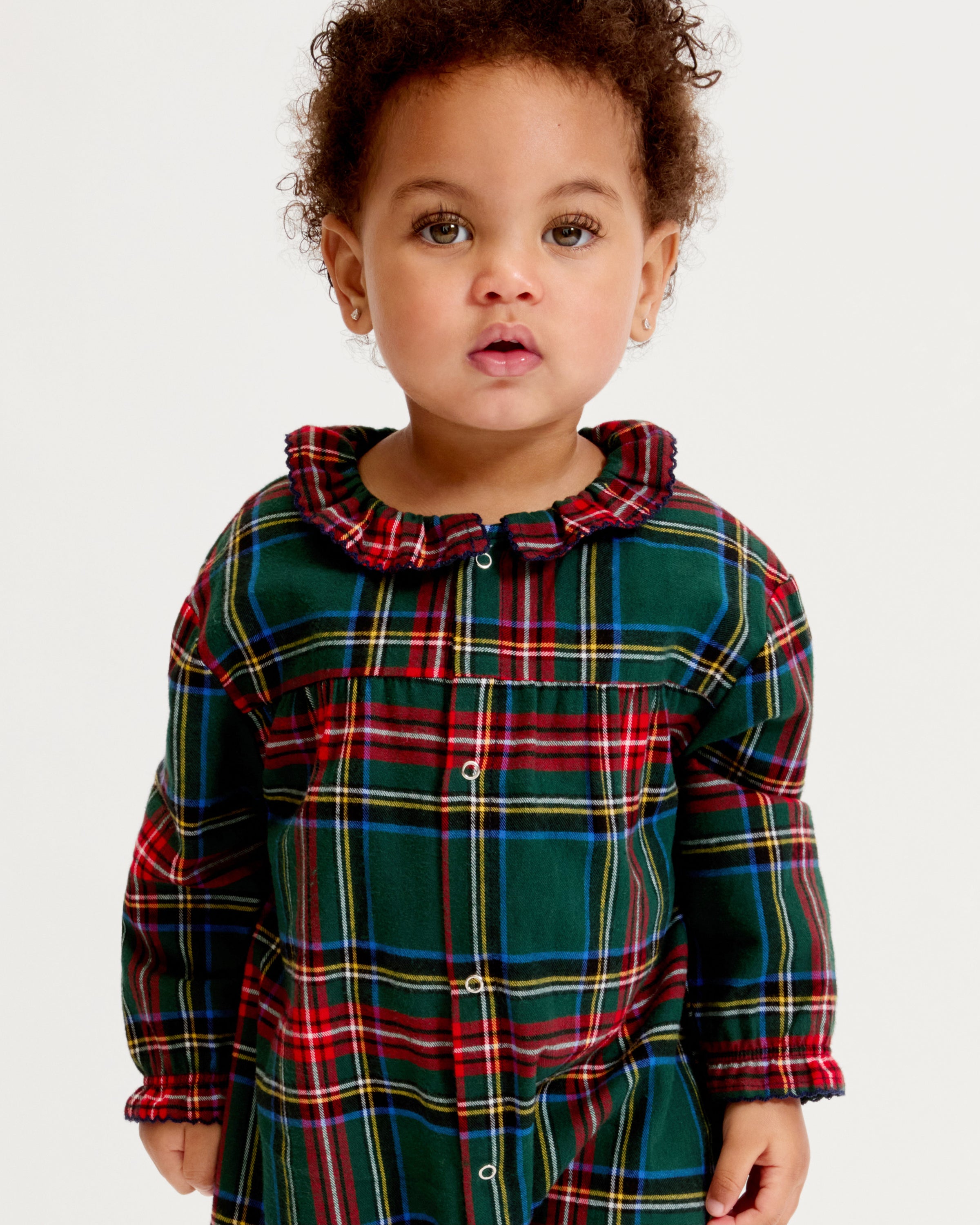 The Baby's Brushed Twill Madeline Romper in Kensington Tartan features a green, red, and yellow plaid print, ruffled collar, button front, and gathered cuffs at the wrists and ankles.