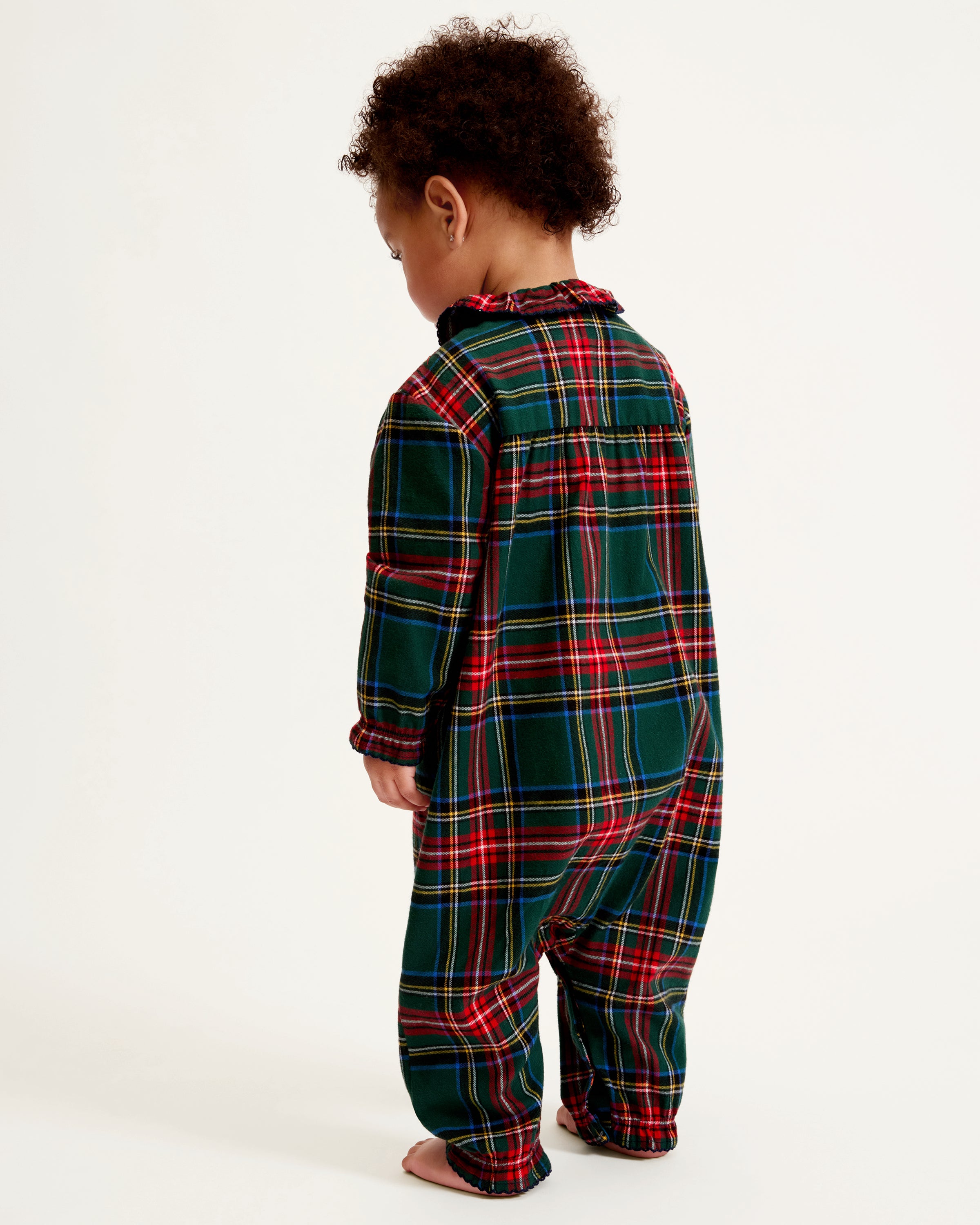 The Baby's Brushed Twill Madeline Romper in Kensington Tartan features a green, red, and yellow plaid print, ruffled collar, button front, and gathered cuffs at the wrists and ankles.