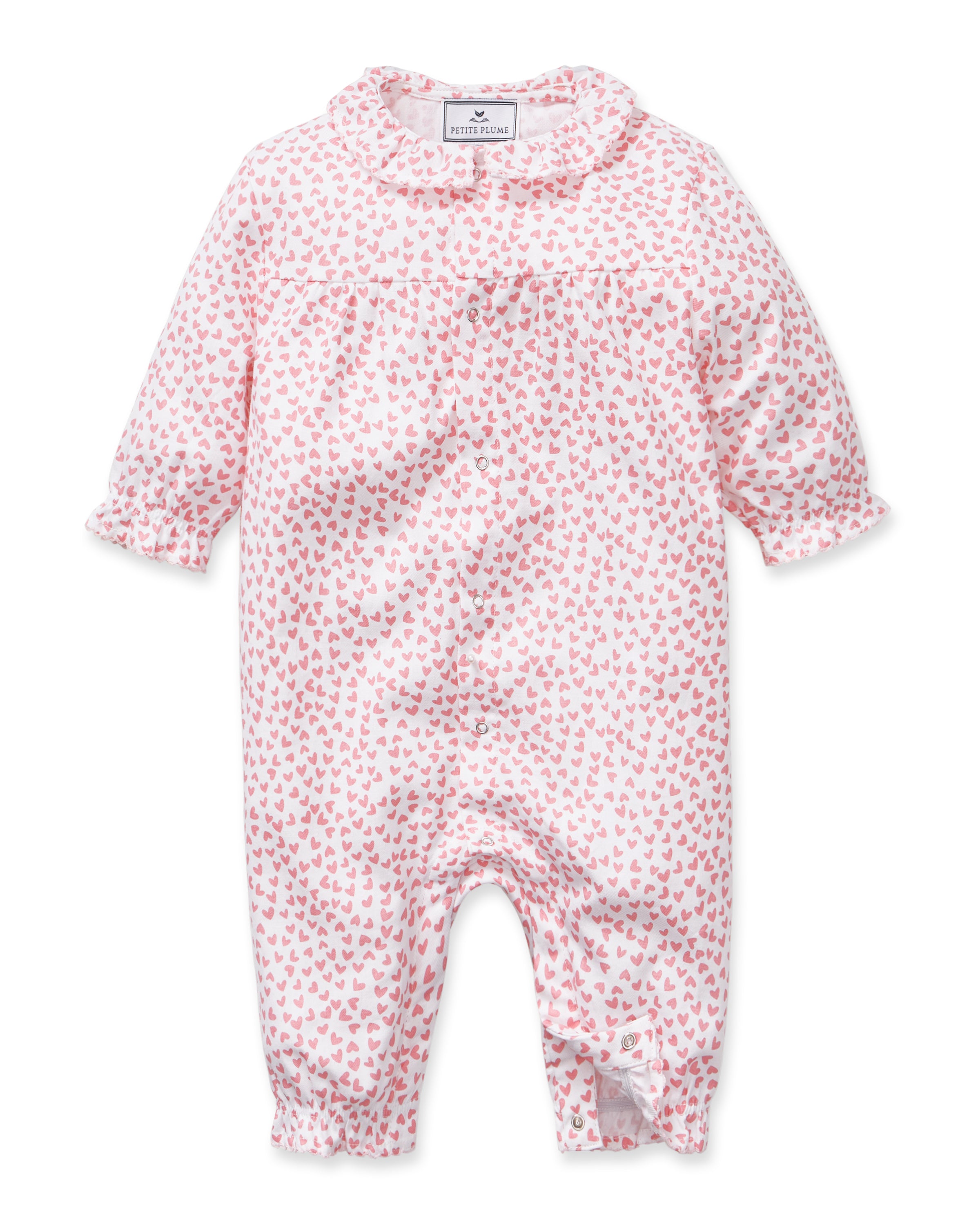 The Baby's Twill Madeline Romper in Sweethearts is a pink and white long-sleeve romper featuring a ruffled collar and cuffs, adorned with a small pink heart pattern.