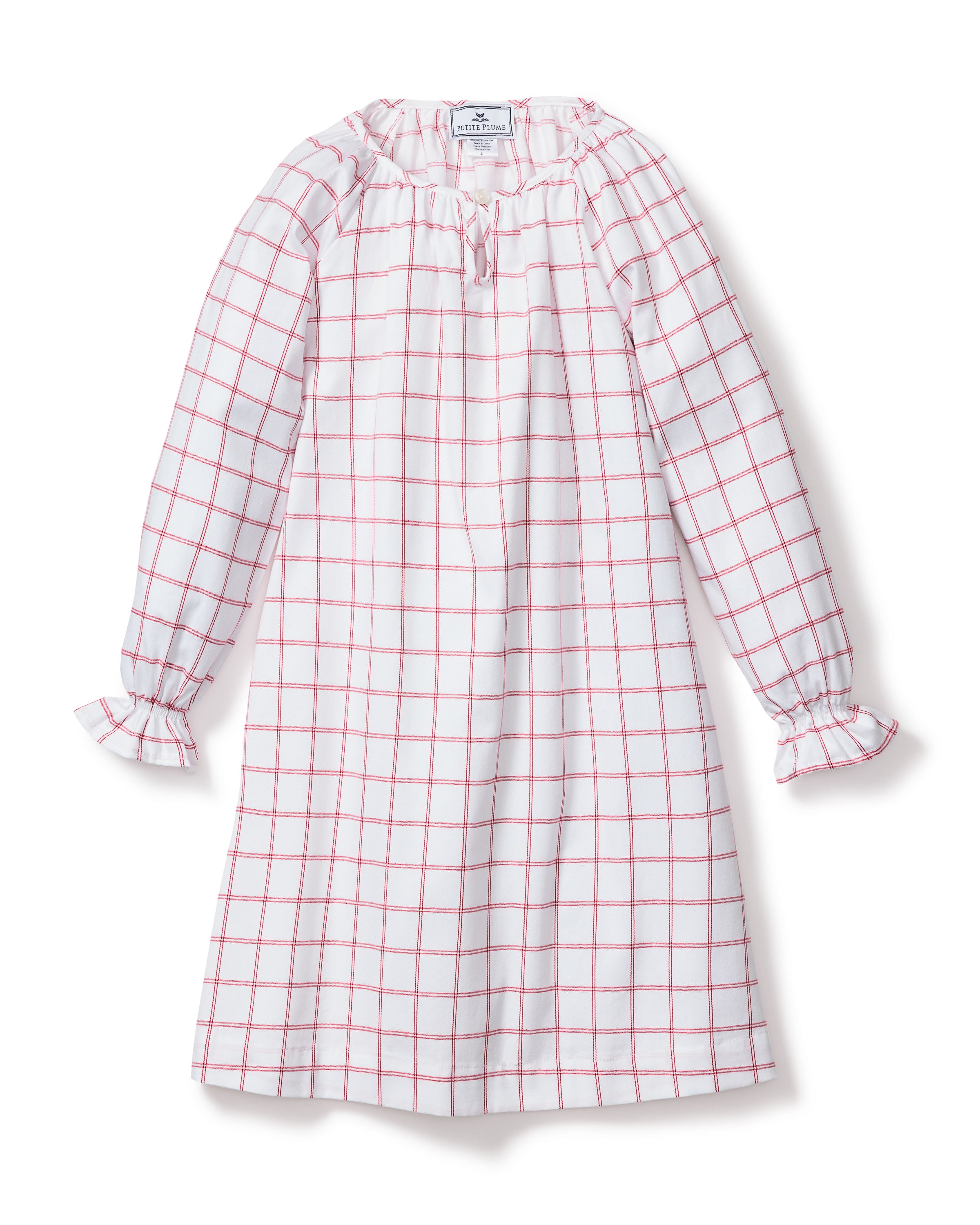 The Girls Twill Delphine Nightgown by Petite Plume in Garnet Tattersall showcases a charming red and white checkered pattern with long sleeves and knee-length. Made from flame-retardant fabric, it features ruffled cuffs and a subtle tie detail at the neckline for safety and style.