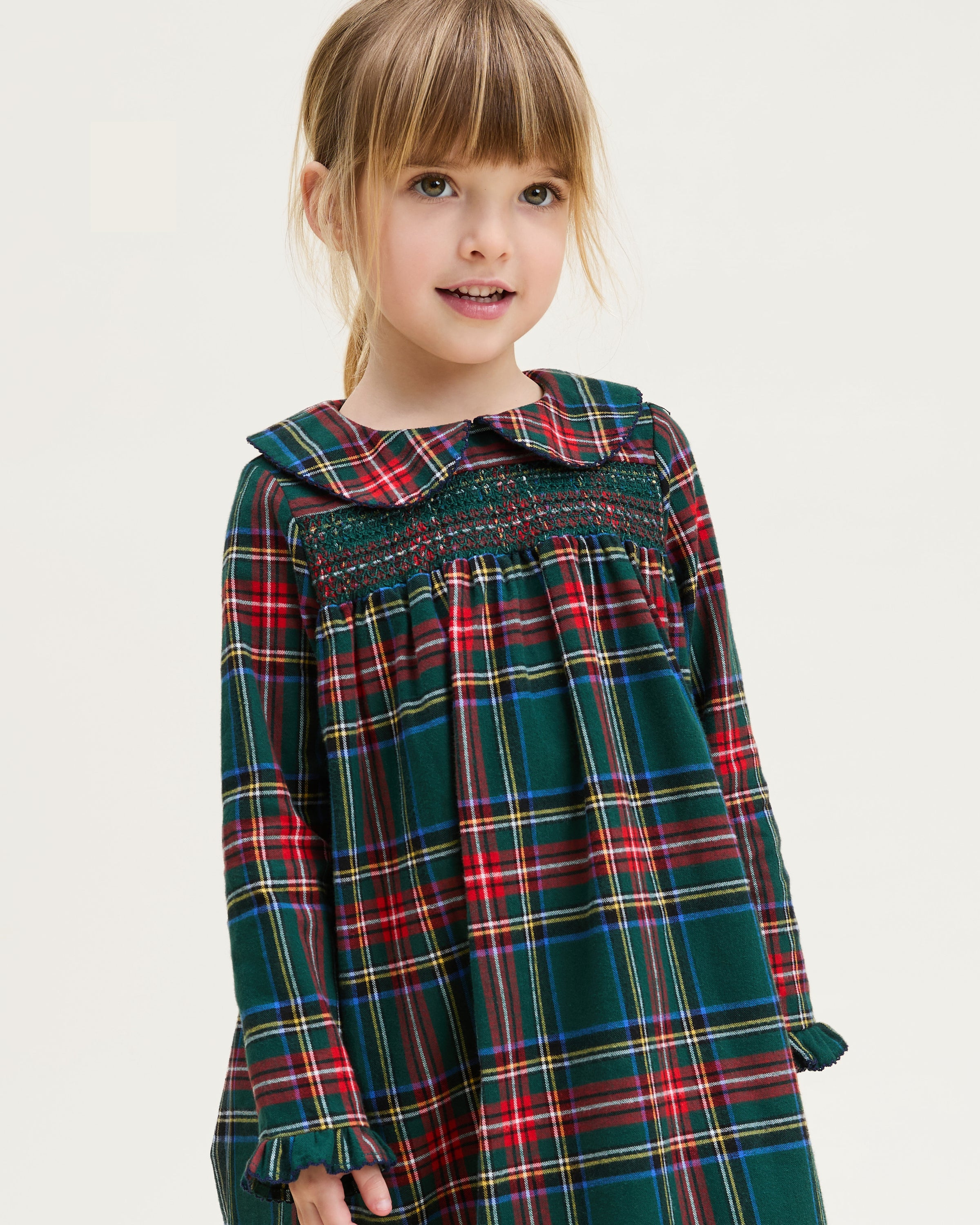 The Girl's Brushed Twill Eloise Nightgown in Kensington Tartan features a green, red, and yellow plaid pattern with long sleeves, a Peter Pan collar, smocked chest, and ruffled cuffs.
