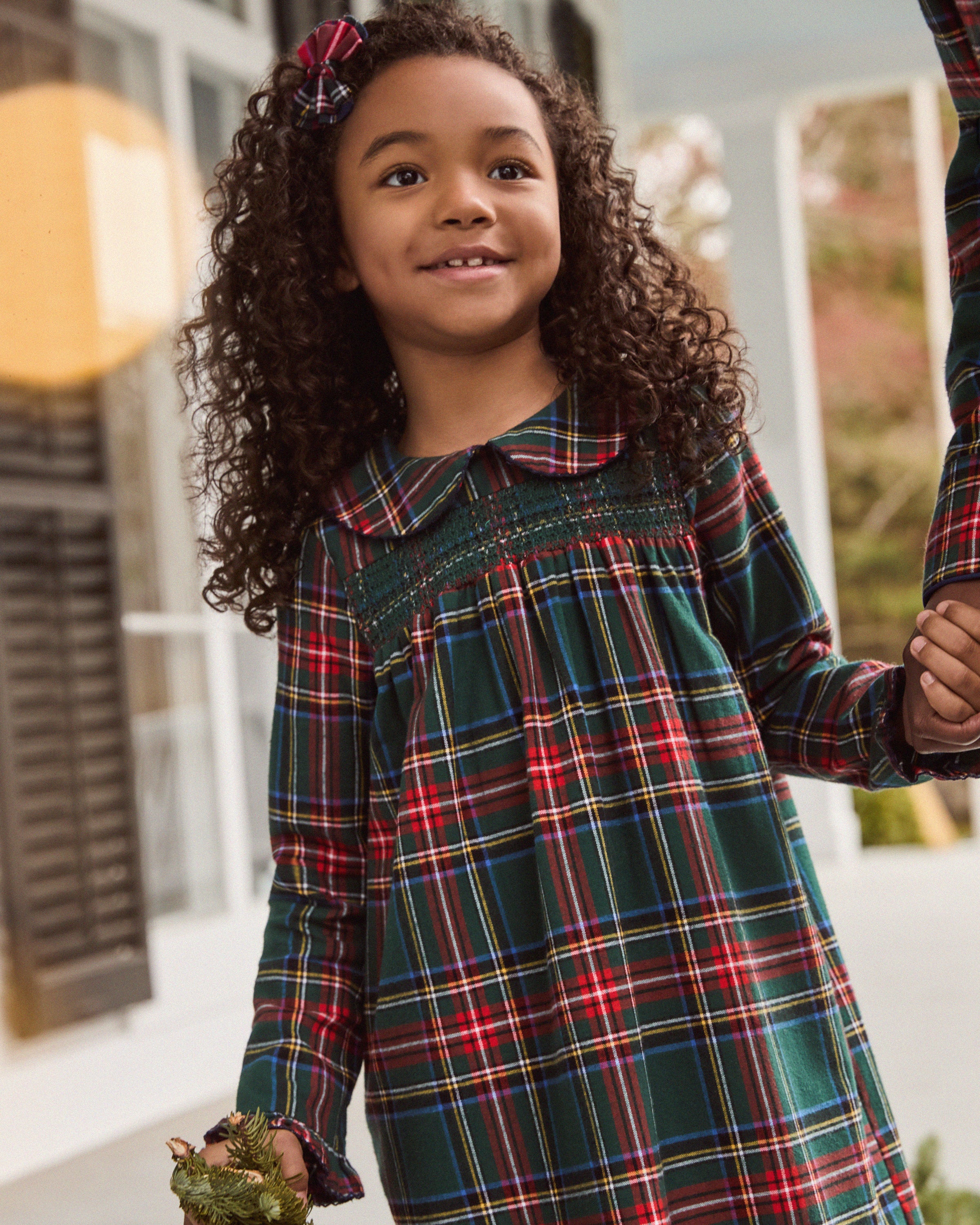 The Girl's Brushed Twill Eloise Nightgown in Kensington Tartan features a green, red, and yellow plaid pattern with long sleeves, a Peter Pan collar, smocked chest, and ruffled cuffs.