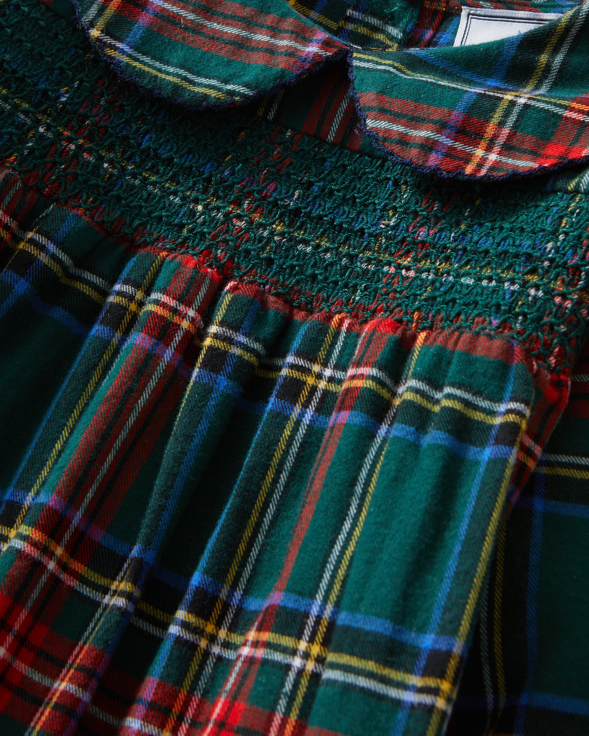 The Girl's Brushed Twill Eloise Nightgown in Kensington Tartan features a green, red, and yellow plaid pattern with long sleeves, a Peter Pan collar, smocked chest, and ruffled cuffs.