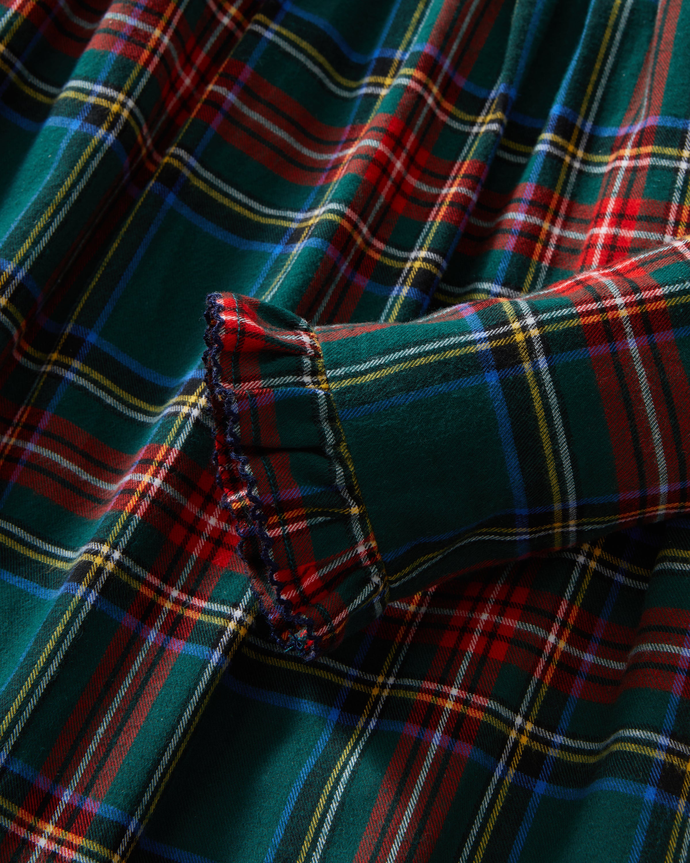 The Girl's Brushed Twill Eloise Nightgown in Kensington Tartan features a green, red, and yellow plaid pattern with long sleeves, a Peter Pan collar, smocked chest, and ruffled cuffs.