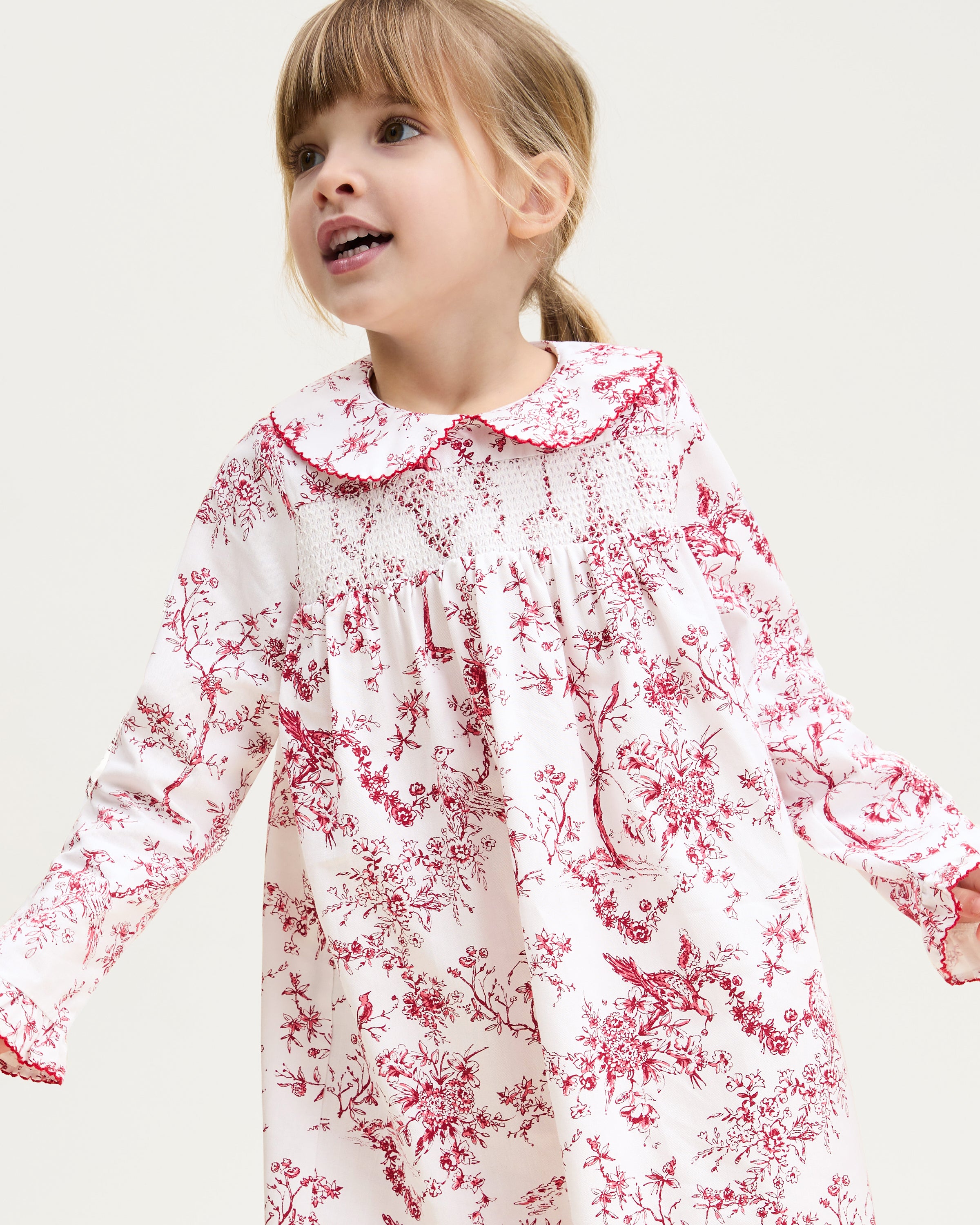 The Girl's Twill Eloise Nightgown in Red Timeless Toile features long sleeves, a white base with red nature-inspired print, gathered yoke, ruffled cuffs, and a scalloped Peter Pan collar.