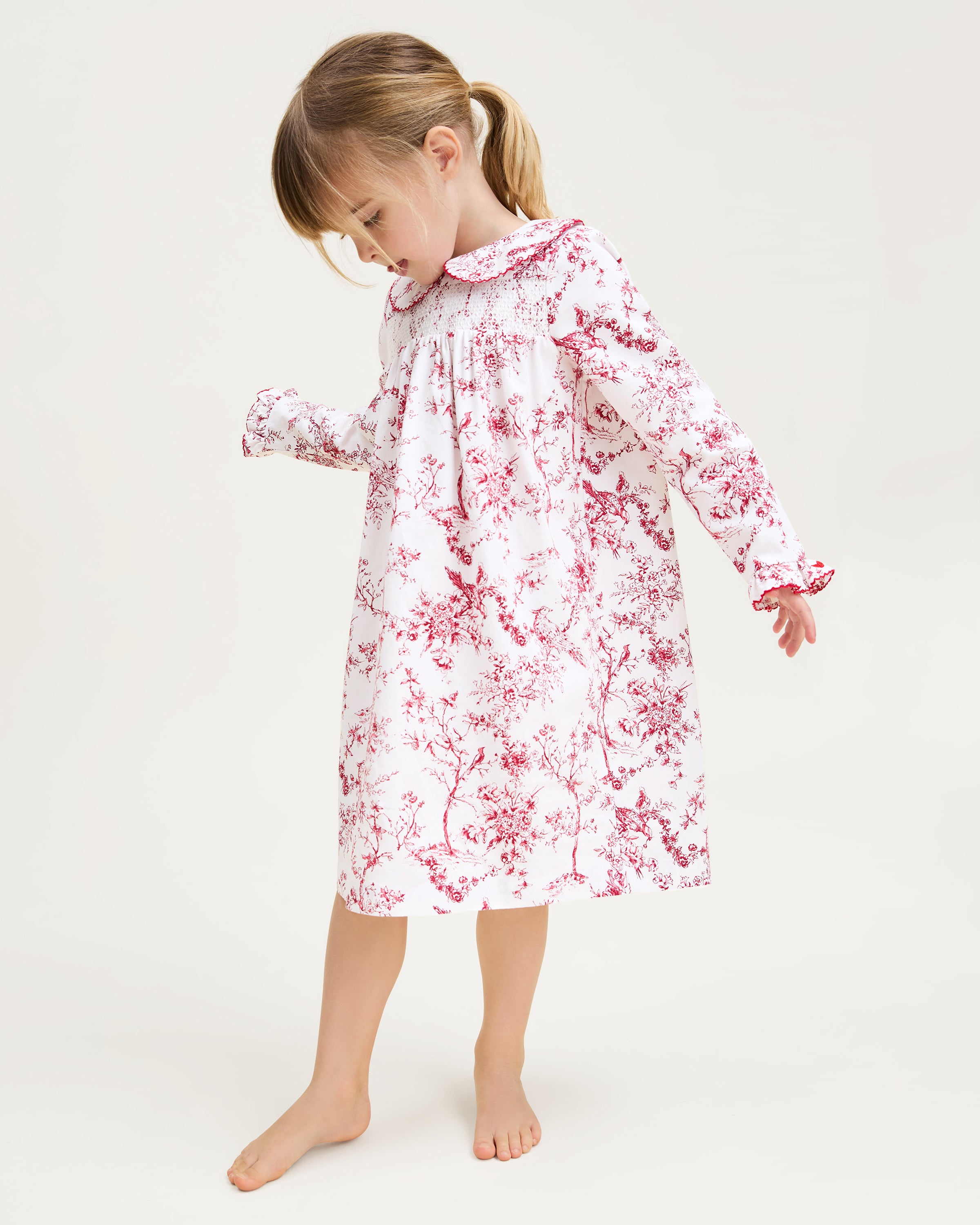 The Girl's Twill Eloise Nightgown in Red Timeless Toile features long sleeves, a white base with red nature-inspired print, gathered yoke, ruffled cuffs, and a scalloped Peter Pan collar.