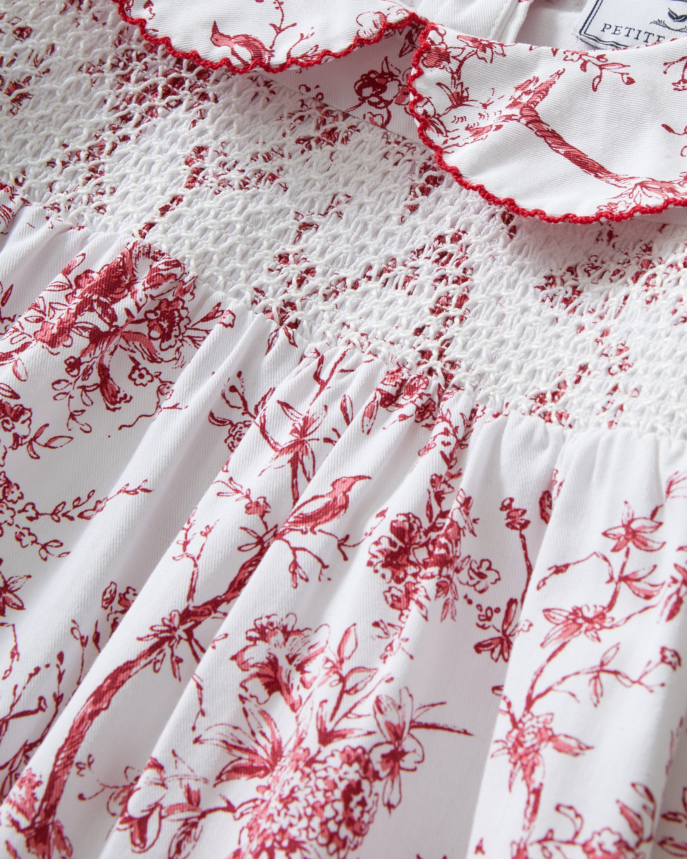 The Girl's Twill Eloise Nightgown in Red Timeless Toile features long sleeves, a white base with red nature-inspired print, gathered yoke, ruffled cuffs, and a scalloped Peter Pan collar.