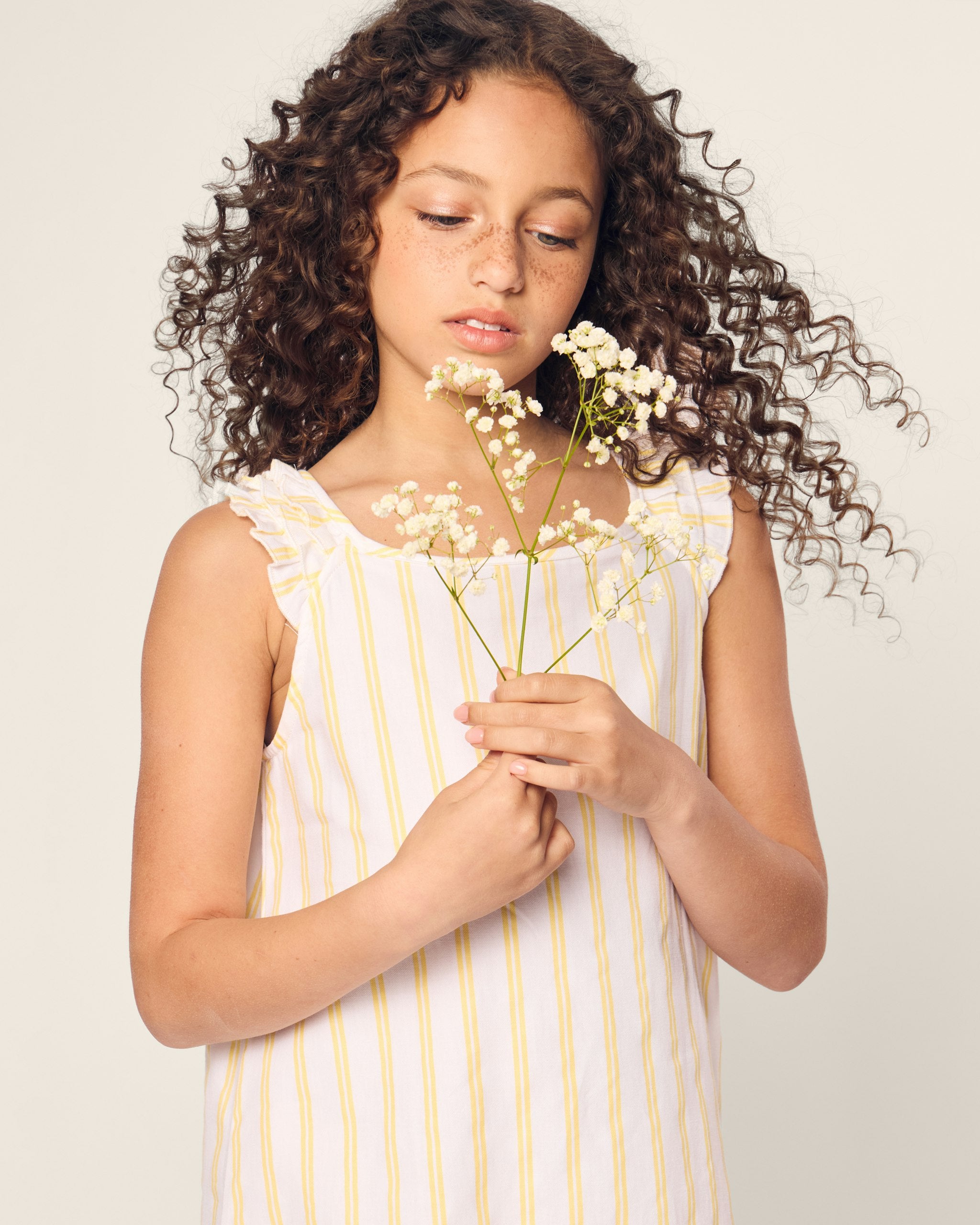 White sleeveless dress with yellow vertical stripes on a white background