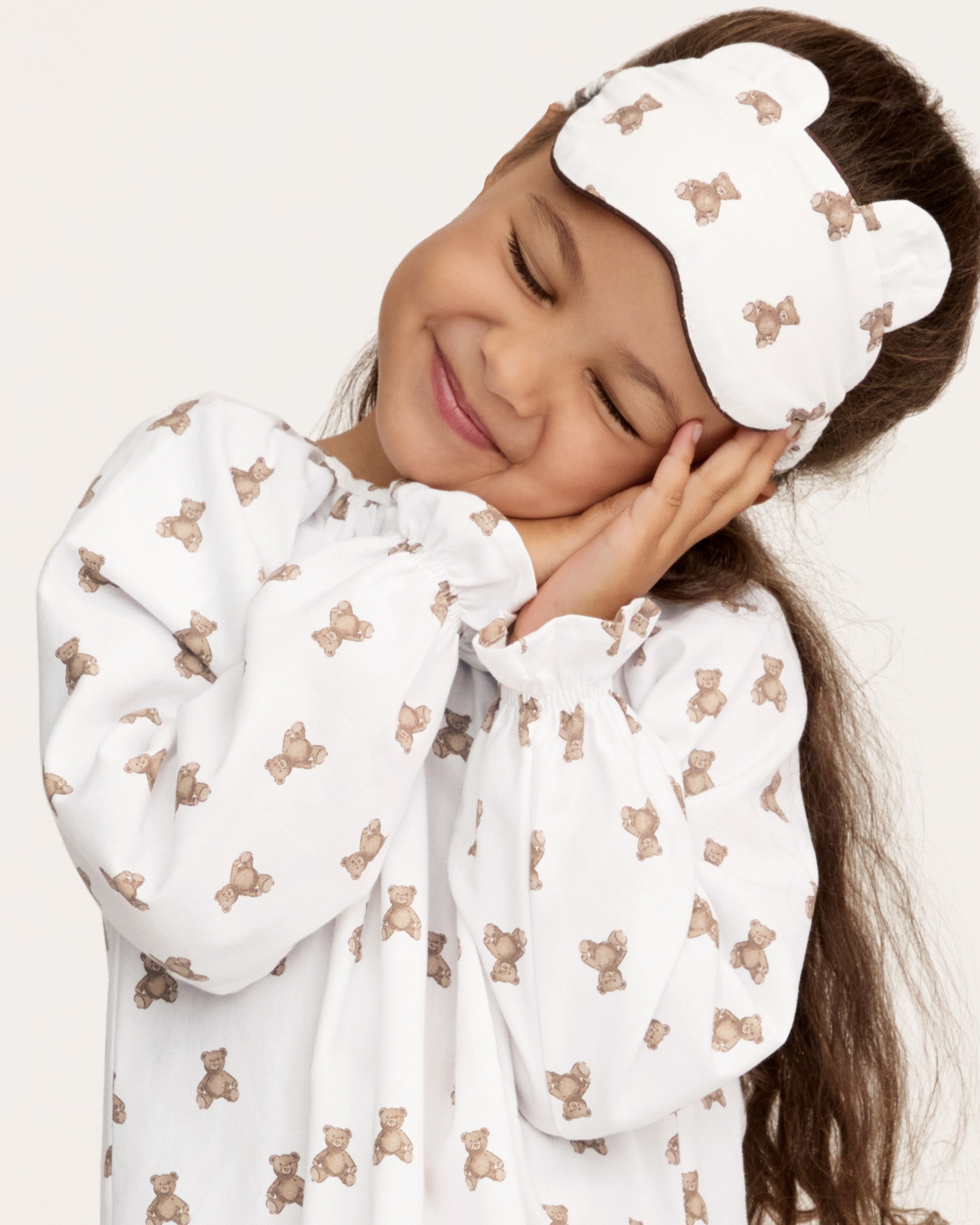 The Girl's Twill Delphine Nightgown in Teddy Tales features long sleeves, a white fabric with an all-over brown teddy bear print, a gathered neckline, ruffled cuffs, and a button closure at the collar.
