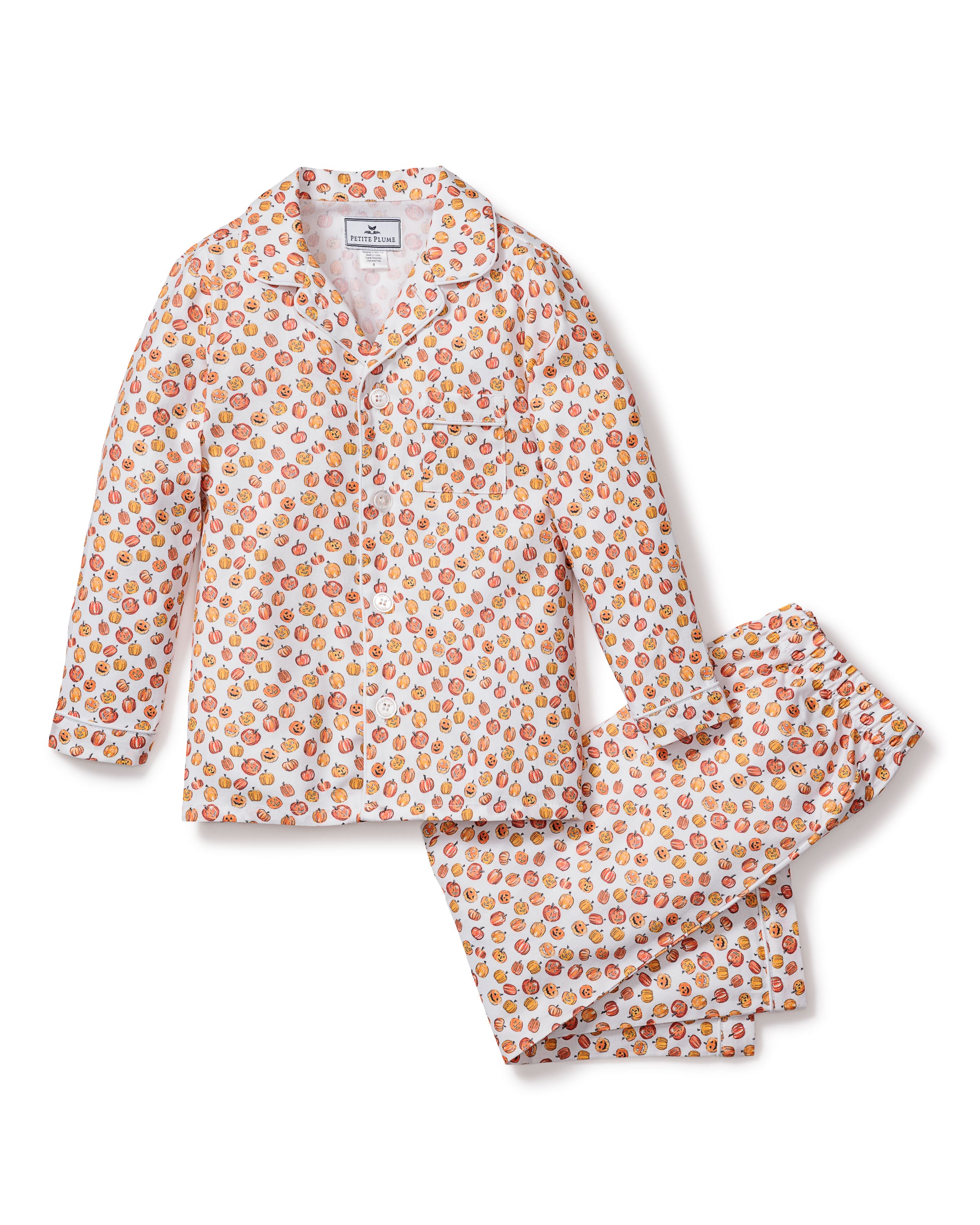 The Kids Twill Pajama Set in Pumpkin Patch by Petite Plume is a two-piece featuring white fabric with an orange fruit pattern. Made from moisture-wicking twill, it includes a long-sleeve button-up shirt with pocket and matching pants, offering a playful design perfect for keeping kids cozy and dry.