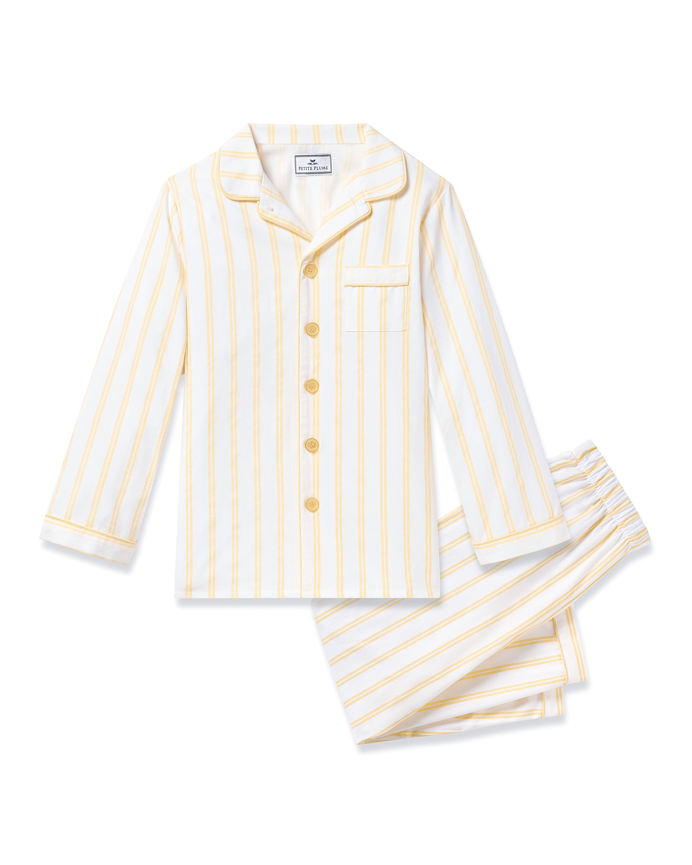 The Kids Twill Pajama in Sunny Stripe by Petite Plume is a delightful childrens set made from yarn-dyed cotton, showcasing yellow and white vertical stripes on a crisp white background. It includes a long-sleeve button-up top with a chest pocket and matching pants with an elastic waistband.