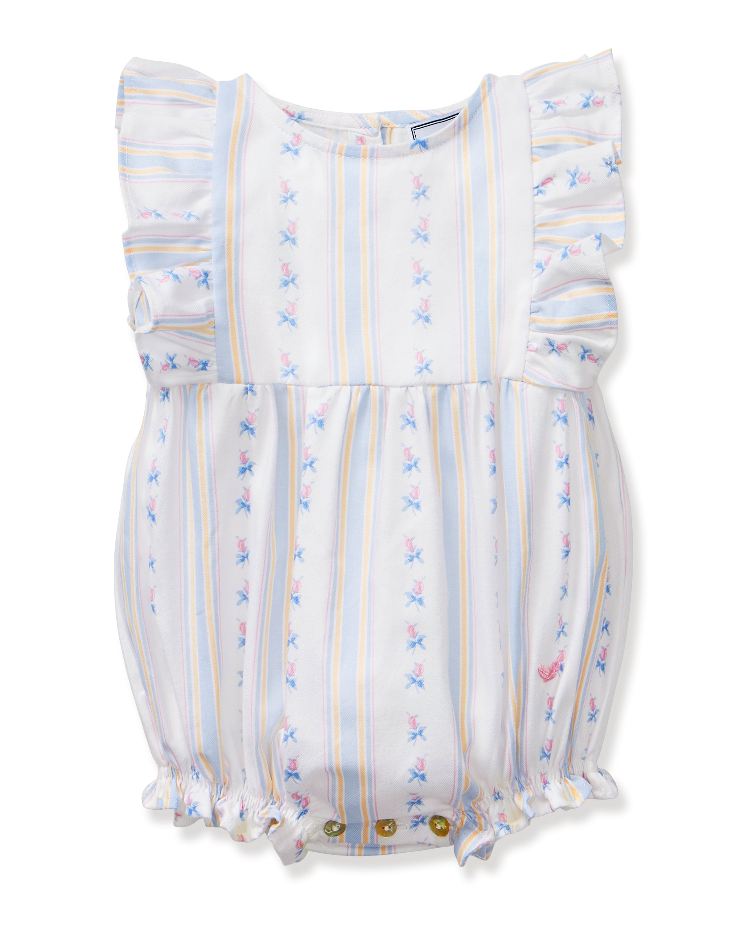 A smiling toddler with curly hair stands barefoot against a plain white background, wearing the Baby's Twill Ruffled Romper in Cottage Stripe—featuring pastel stripes, small floral patterns, and ruffled sleeves.