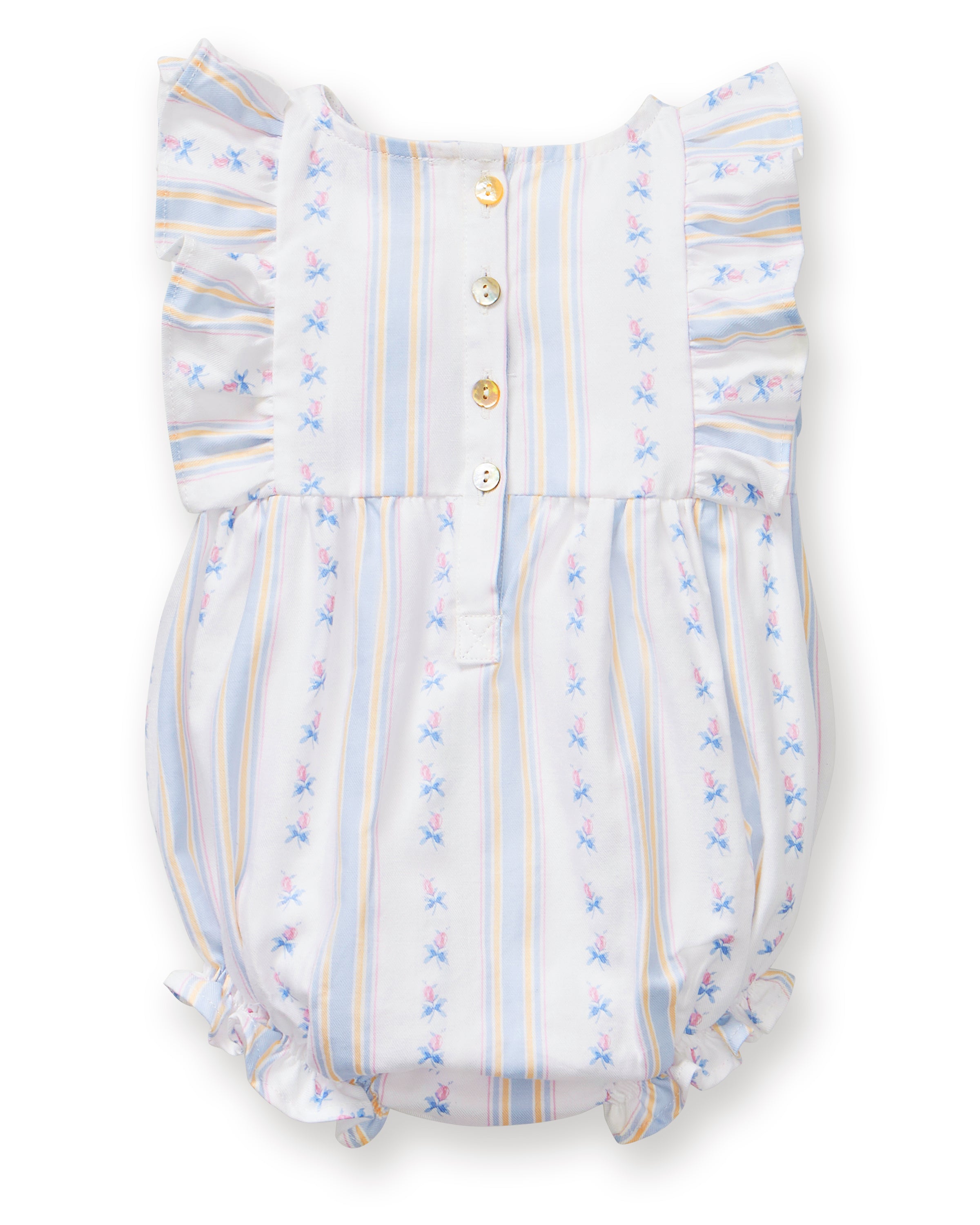 A smiling toddler with curly hair stands barefoot against a plain white background, wearing the Baby's Twill Ruffled Romper in Cottage Stripe—featuring pastel stripes, small floral patterns, and ruffled sleeves.