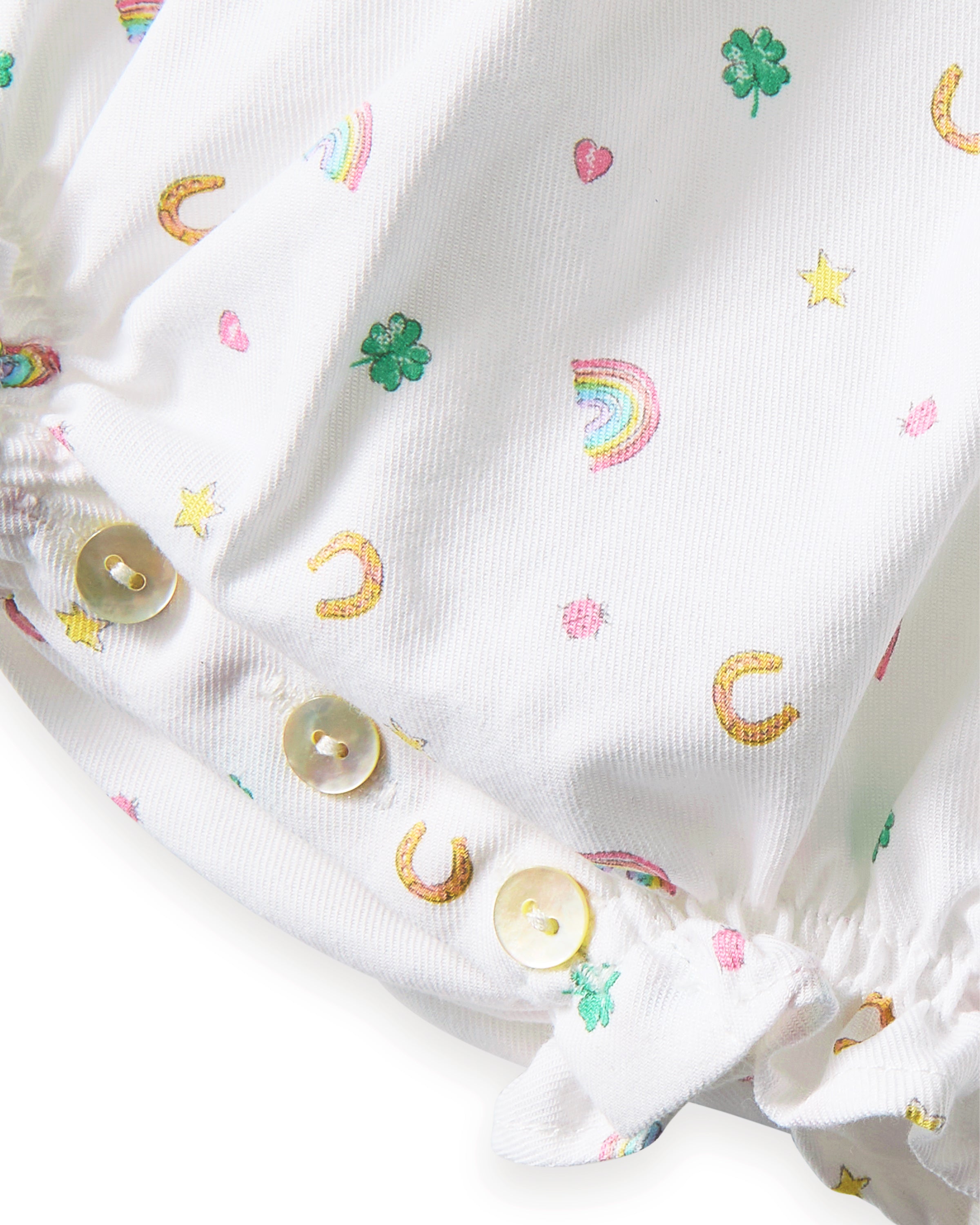 Baby's Twill Ruffled Romper in Good Luck Charms features small colorful prints of rainbows, horseshoes, clovers, and stars, ruffled sleeves, elastic leg openings, and a tag at the neckline.