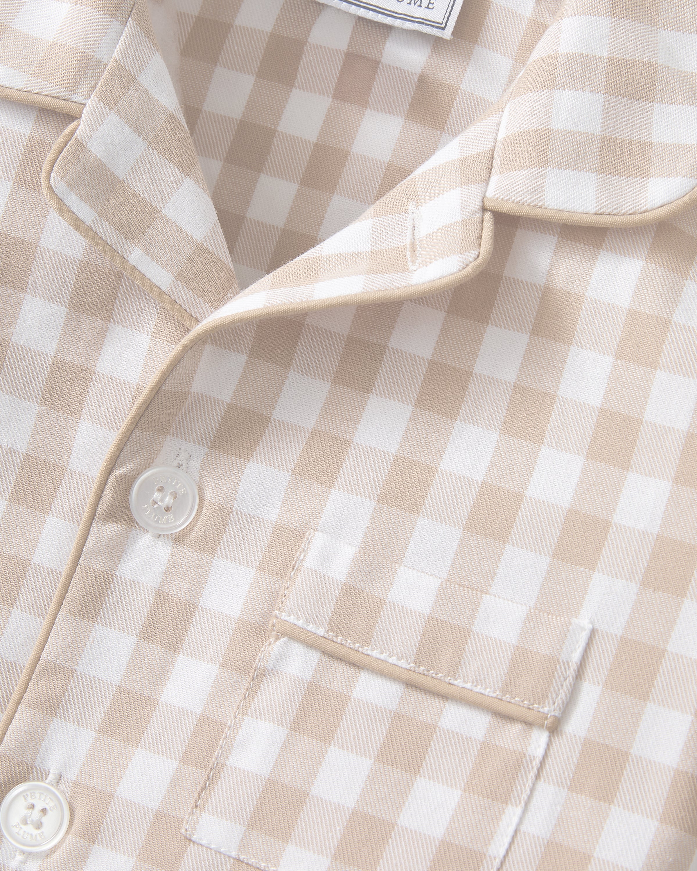 The Kid's Twill Pajama Short Set in Camel Gingham features a light beige and white gingham pattern with a collared, button-front top, chest pocket, and elastic waist shorts.