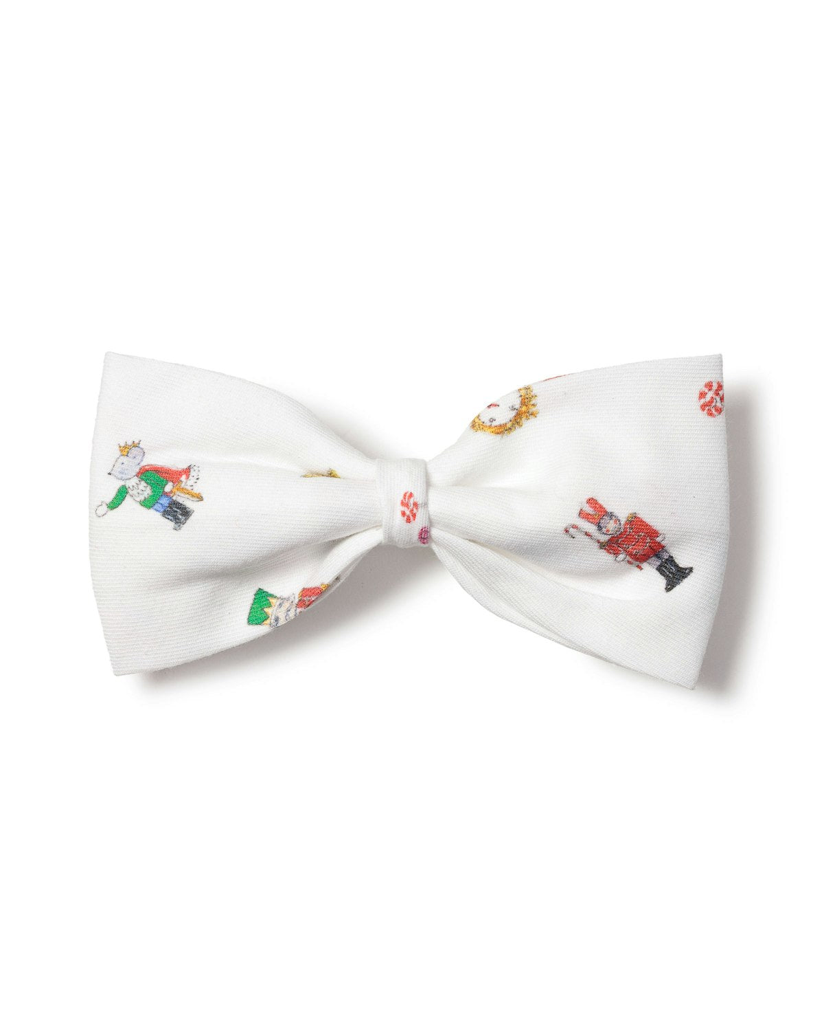 The Petite Plume A Night at the Nutcracker Dog Bow Tie is white and adorned with festive illustrations like Santa Claus, Christmas trees, candy canes, and snowflakes, creating a cheerful holiday accessory for your furry friend.