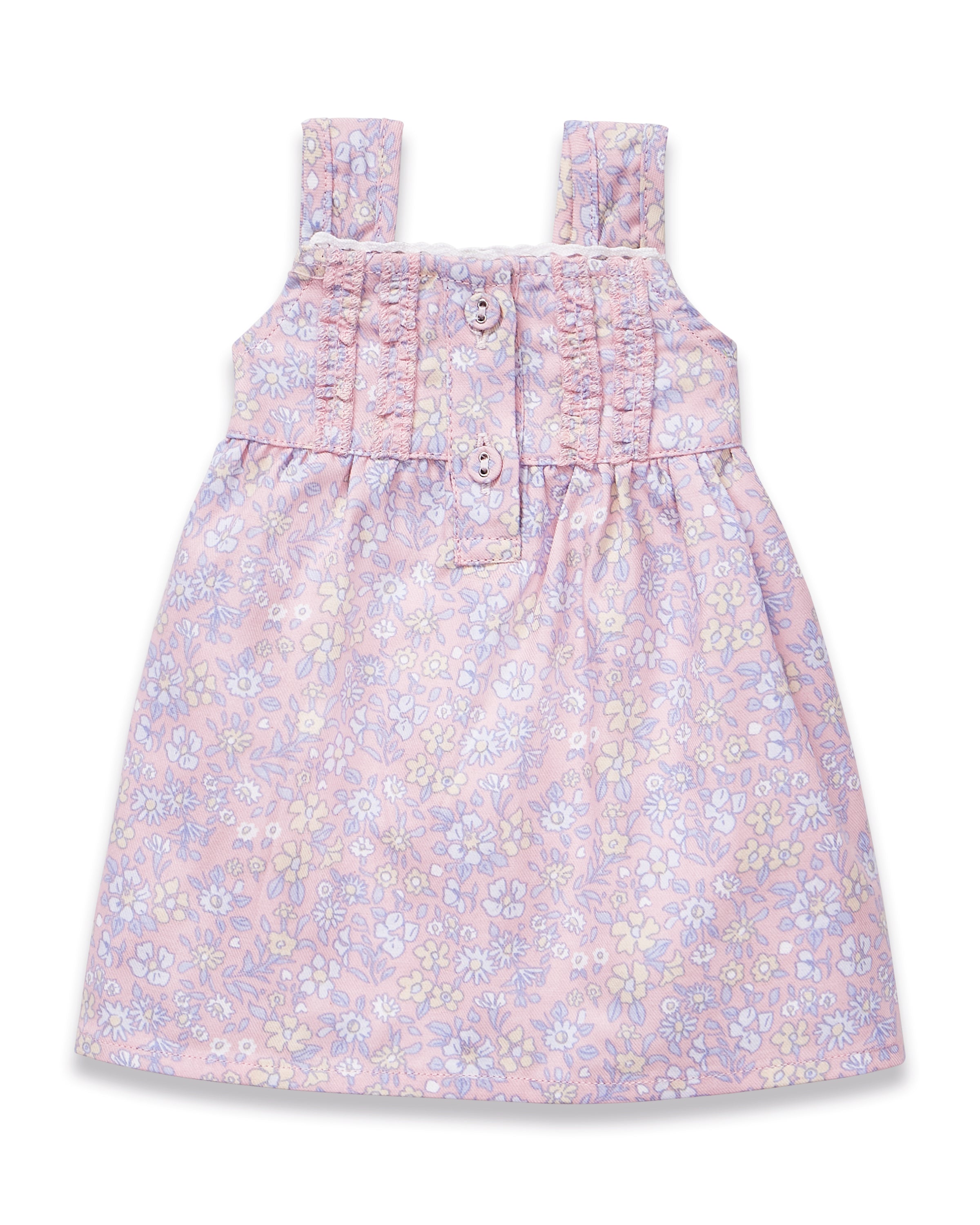 The Kid's Twill Doll Nightgown in Fleur Blush is a pink sleeveless dress with wide straps, front buttons, and a pastel floral print in white, yellow, and blue. It features a gathered waist and is made from soft, lightweight fabric.