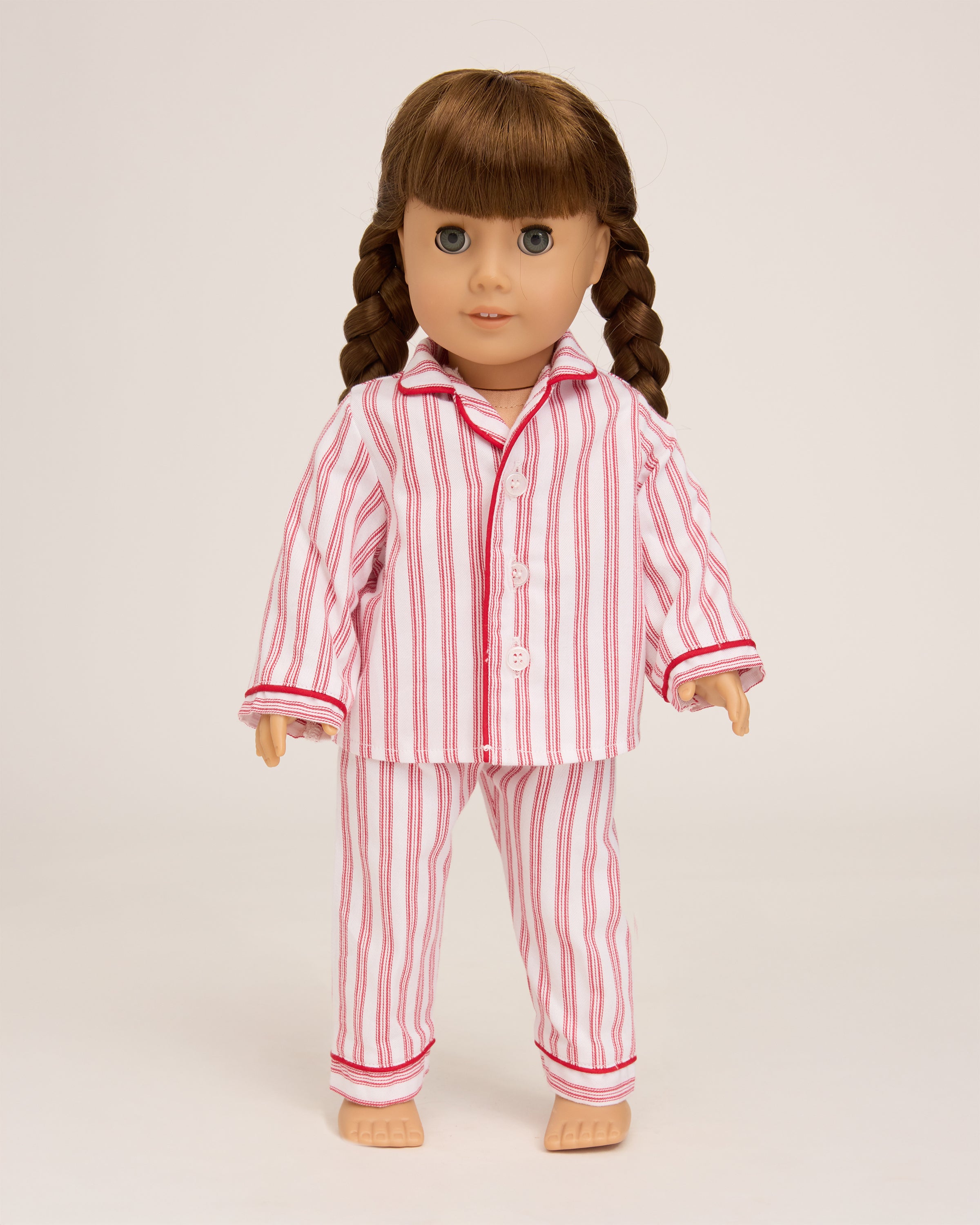 The Petite Plume Doll Pajamas in Antique Red Ticking include a red and white striped childs pajama set with a collared button-up top and relaxed pants with cuffed hems. Ideal for bedtime fun, they allow your child to match their favorite 18 doll in cozy style.