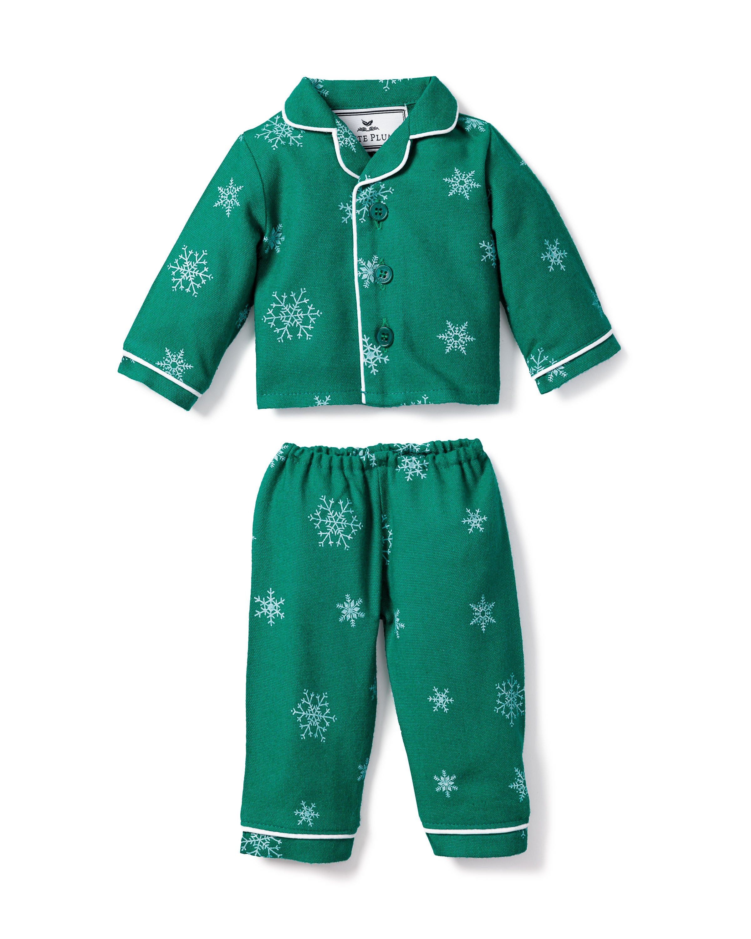 The Petite Plume Kids Flannel Doll Pajamas in Emerald Wonderland feature a cozy green set with white snowflake patterns, button-up top, and elastic-waist pants—perfect for dreamland or twinning with your 18 doll.