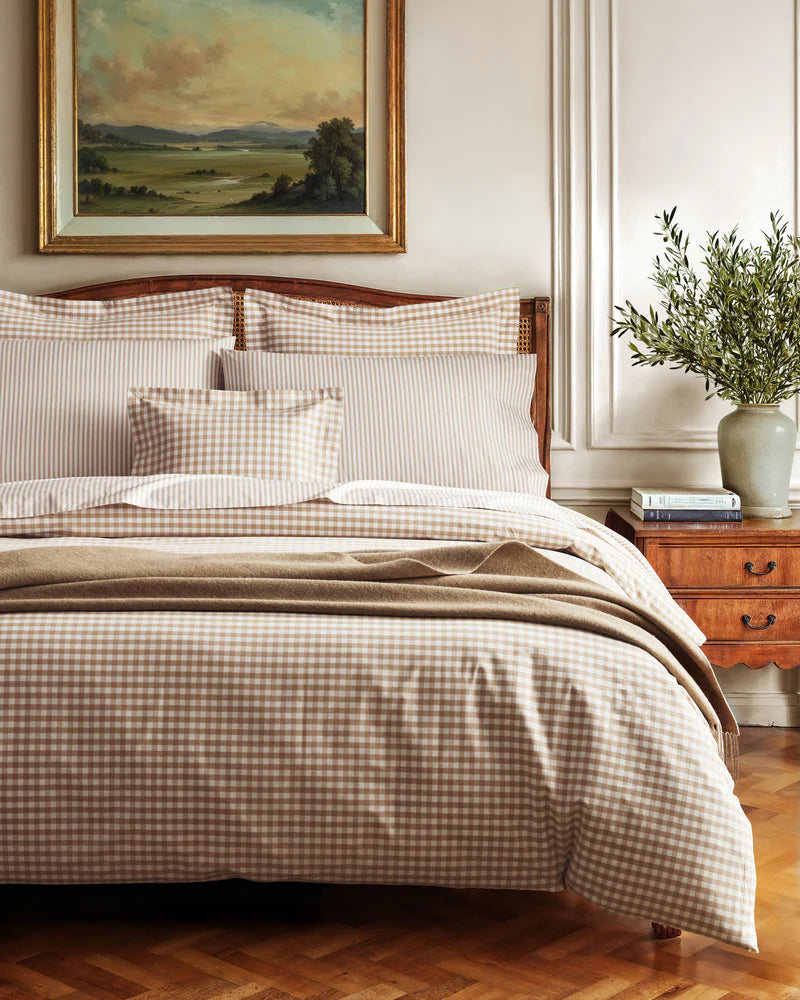 Bedroom with checkered bedding, wooden headboard, and decorative elements.