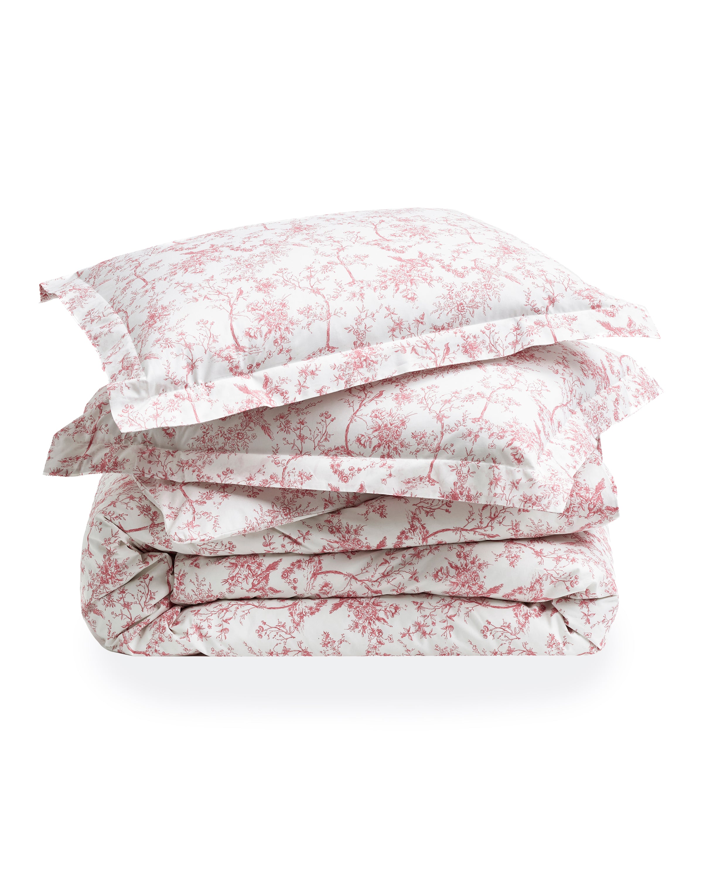 A neatly made bed features the Pink Timeless Toile Bedding Set with white sheets, a pink floral comforter, and two matching pillows against a curved, upholstered headboard in an elegant, classic bedroom.