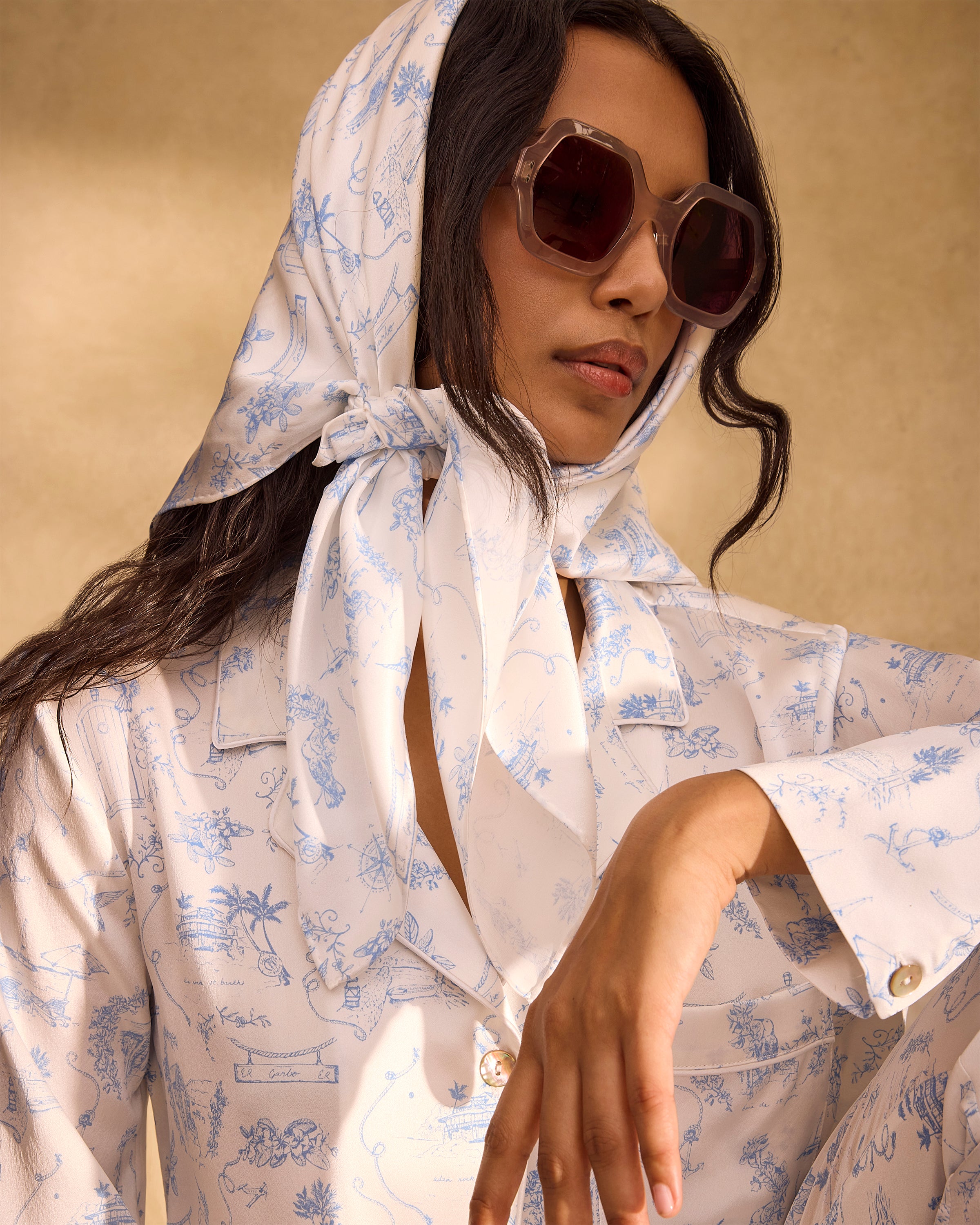 The Petite Plume x Eden Rock Blue Reverie Silk Scarf features delicate blue floral and botanical patterns on white silk, shown loosely folded on a plain white background.