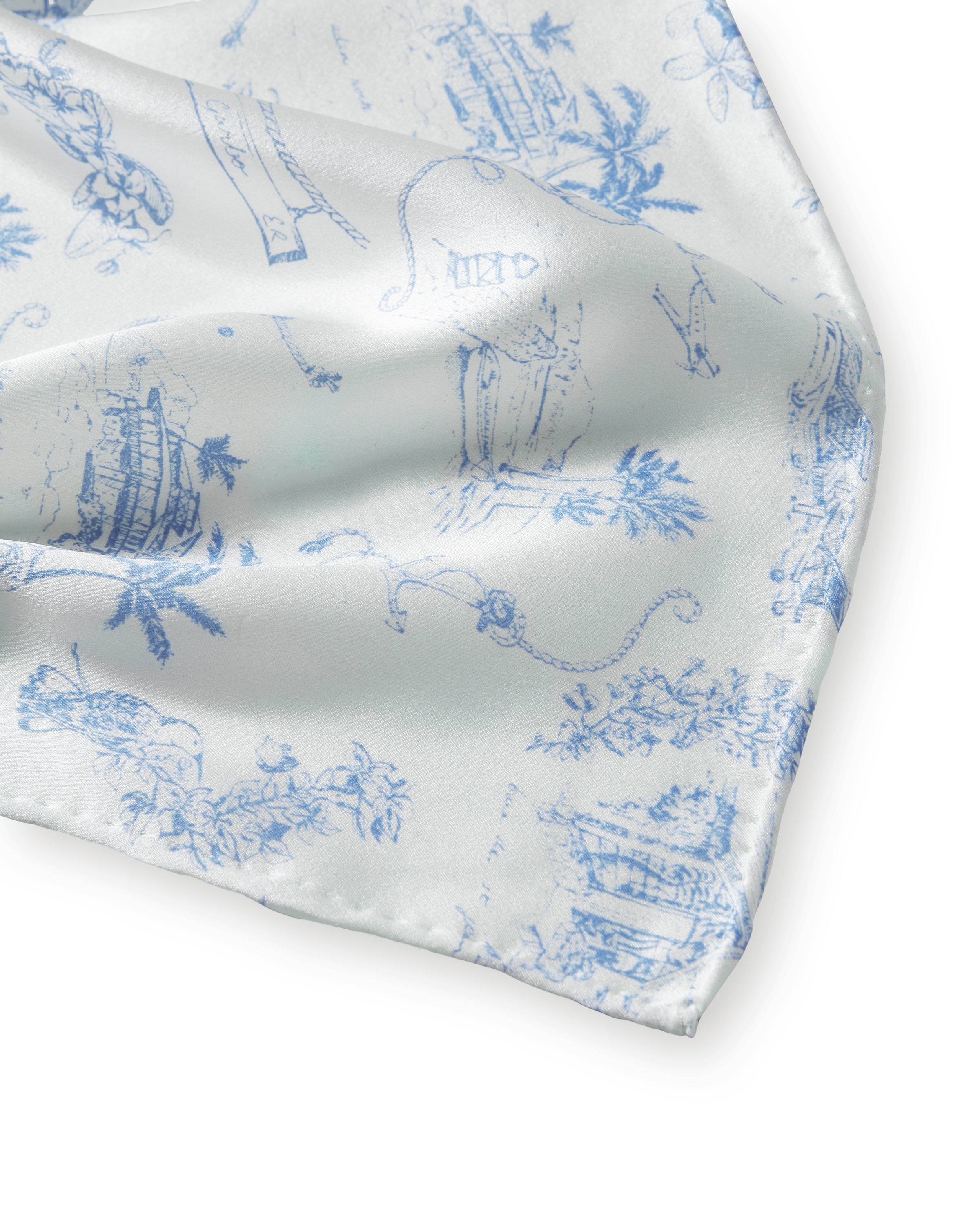 The Petite Plume x Eden Rock Blue Reverie Silk Scarf features delicate blue floral and botanical patterns on white silk, shown loosely folded on a plain white background.