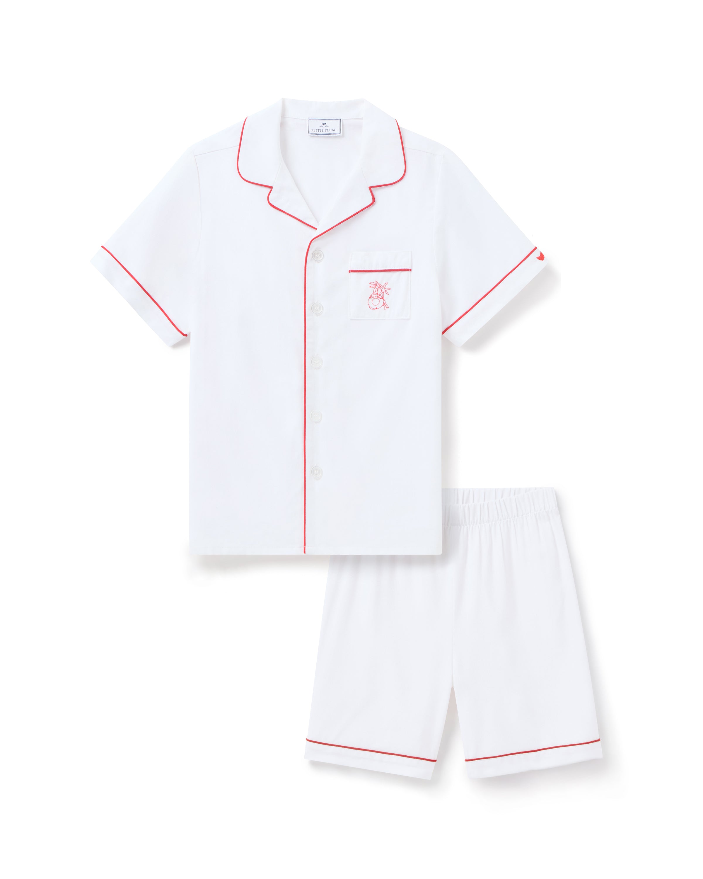 Indulge in luxurious sleepwear with the Petite Plume x Eden Rock St Barth Kids White Twill Short Set. This limited-edition two-piece features a short-sleeve button-up top with red piping, embroidered chest pocket, and matching shorts for elegant nights.