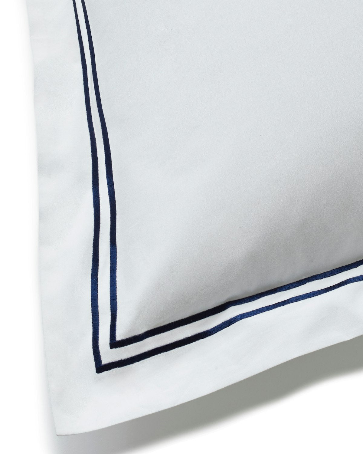 The Luxe Premium Percale Euro Sham by Petite Plume features a cozy, white look with a double navy blue border, showcasing its smooth percale fabric and elegant, minimalistic design.