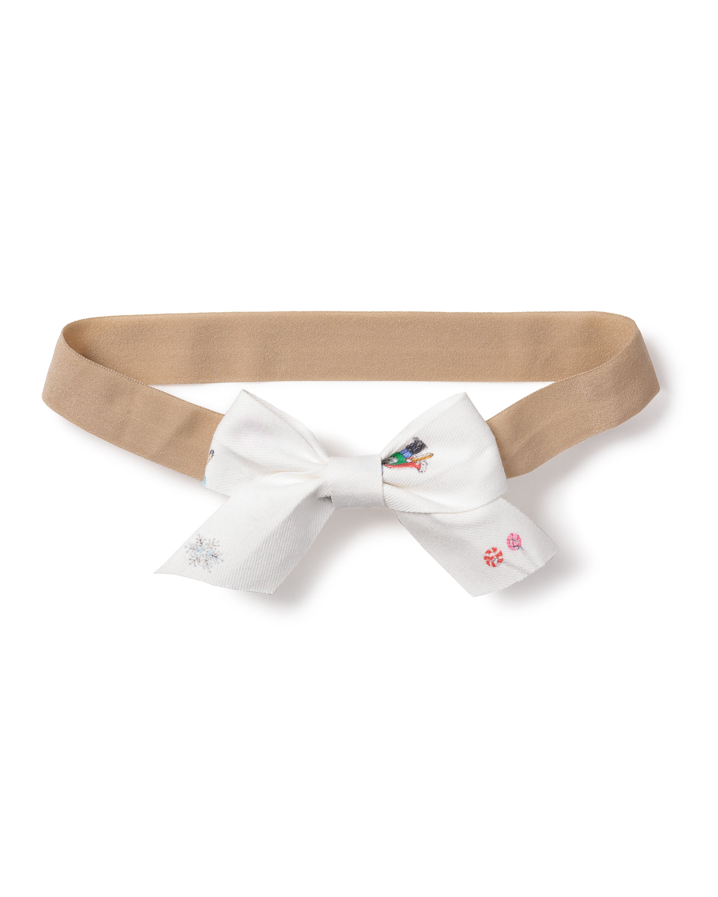 A Girls Twill Hair Bow by Petite Plume in A Night at the Nutcracker features a beige headband with a central white bow and colorful embroidery of a penguin, snowflakes, and candy canes.