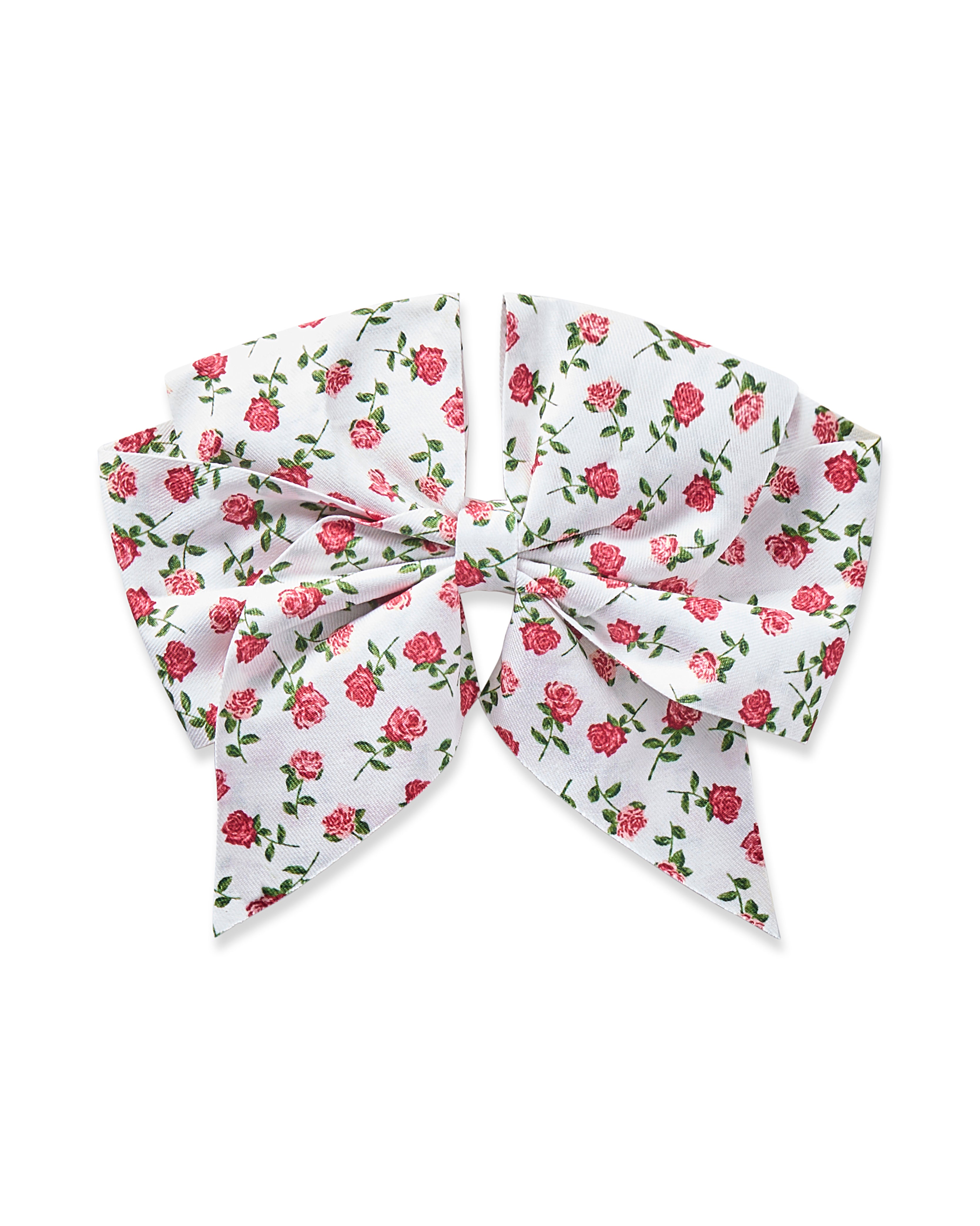 The Girls Twill Hair Bow from Petite Plume features a white design with small pink roses and green leaves, perfect for accessorizing girls pajamas. Tied elegantly with pointed ends, it showcases a lovely floral pattern called Petite Petals.