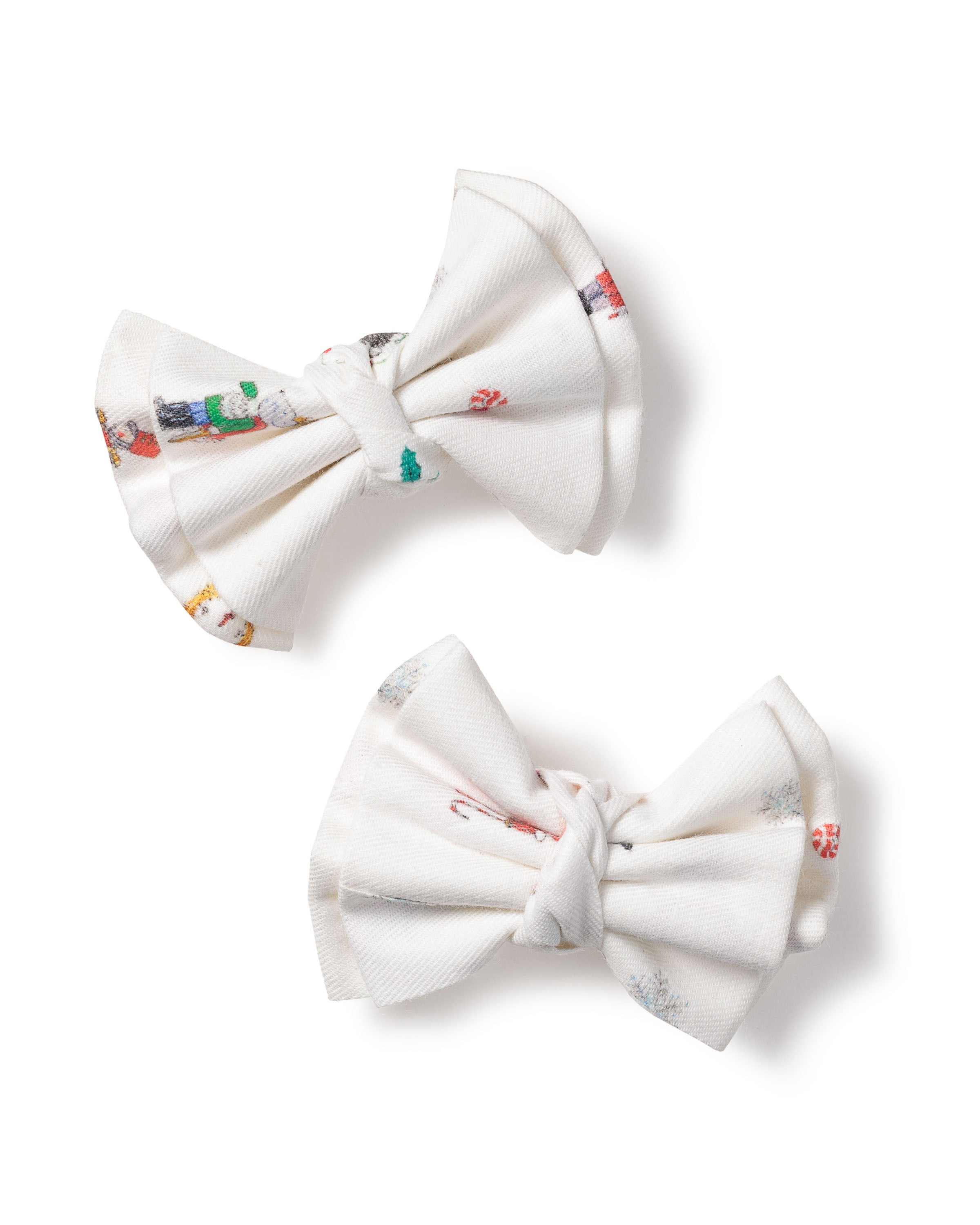 Petite Plumes Girls Twill Hair Bows in A Night at the Nutcracker feature white fabric with colorful patterns, including snowmen and candy canes, set against a plain white background, evoking the enchanting touch of the Sugar Plum Fairy.