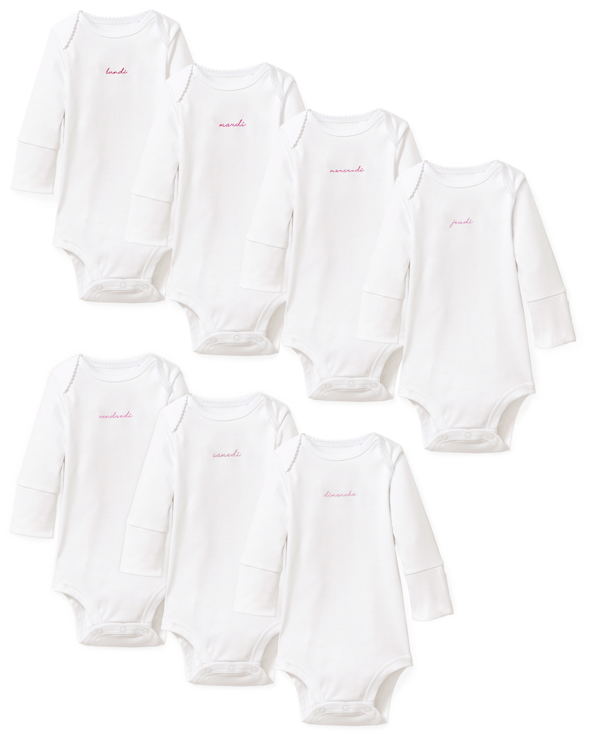 Seven white long-sleeve Baby’s Pima Onesies from the French Lessons Pink set are shown, each featuring a day of the week embroidered in pink cursive Spanish lettering on the chest.