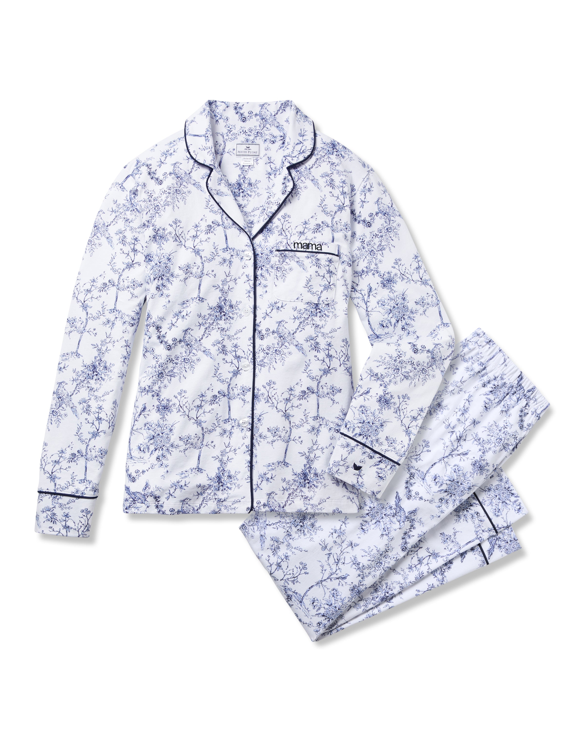 The Womens Pima Pajama Set in Timeless Toile by Petite Plume features a white base with elegant blue floral patterns. This luxury sleepwear includes a long-sleeve button-up top with collar and chest pocket, matching pants, and dark blue piping.