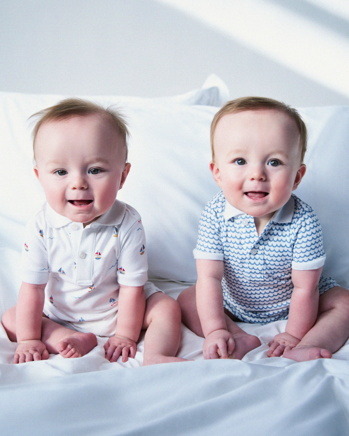 White baby romper with sailboat pattern on a white background