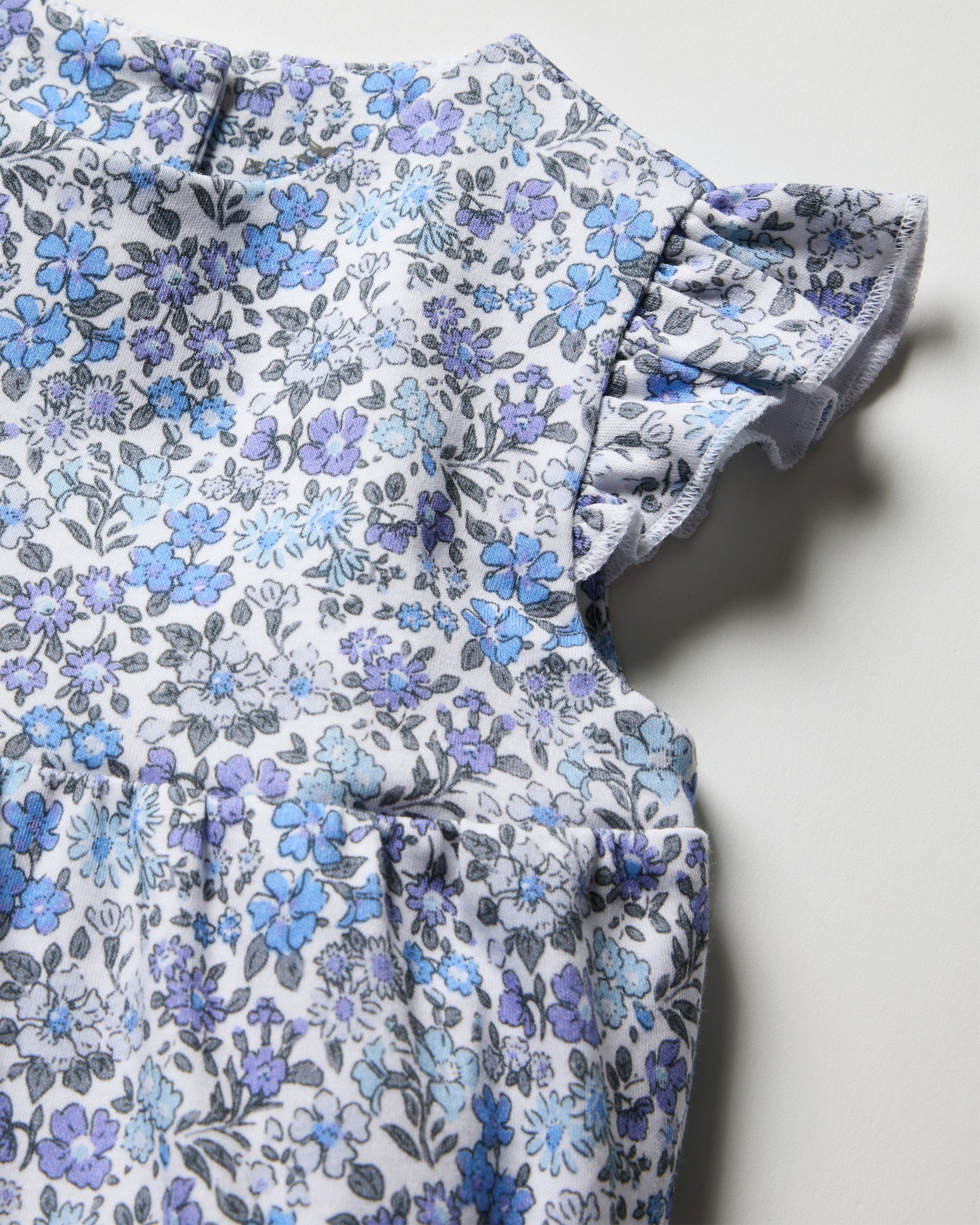 Floral-patterned baby romper on a white background