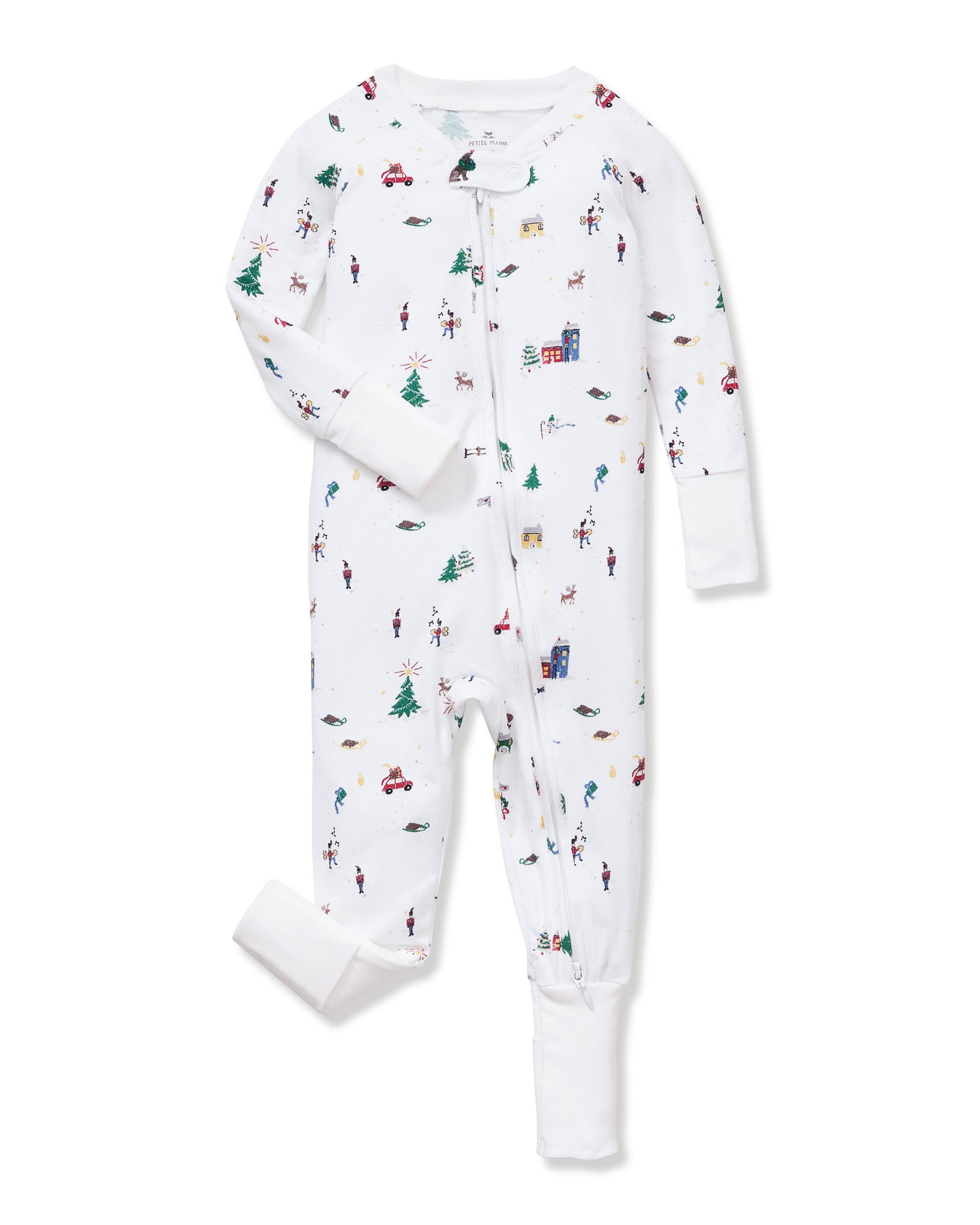 The Baby's Pima Peekaboo Romper in Holiday Town is a white, footless, long-sleeve pajama featuring small colorful prints of trees, cars, cabins, skiers, and people, with a round neckline and snaps down the front and legs.